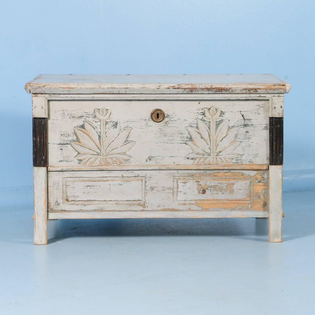 This mid-19th century antique Hungarian trunk retains it's original gray paint. It is slightly worn in places exposing the natural pine, which gives it a wonderful country feel. The front is decorated with two botanical carvings over two faux