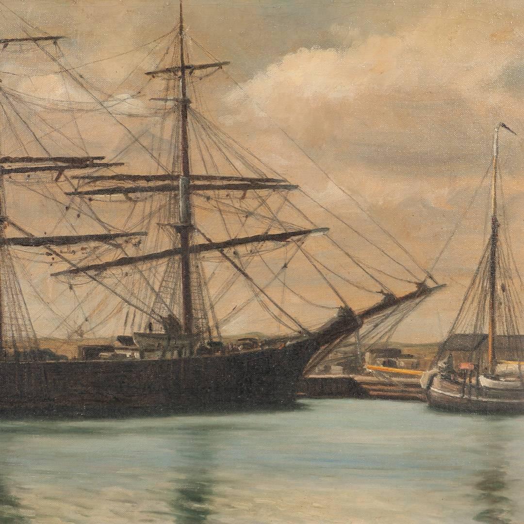 Antique marine oil on canvas painting of a two-masted schooner in a harbor by Danish artist Viggo Helsted (1861-1911). The two masted schooner appears to be moored at the dock, a dark silhouette against the village and warehouses, surrounded by