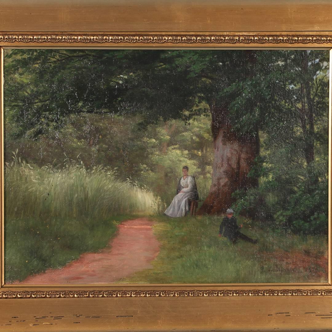 Antique oil on canvas painting of a mother watching over her son while sitting on a bench, under the shade of a large tree next to a path through the green grass and woods. Danish school, unsigned and in a period gilt frame. Please enlarge and