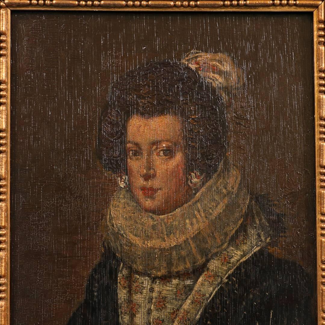 Unsigned antique Dutch painting of a young woman of the 17th century, painted on a wood panel, circa 1840. The panel is mounted in an antique black and parcel giltwood frame which is the same as the other two companion pieces, #20626 and #20627.
