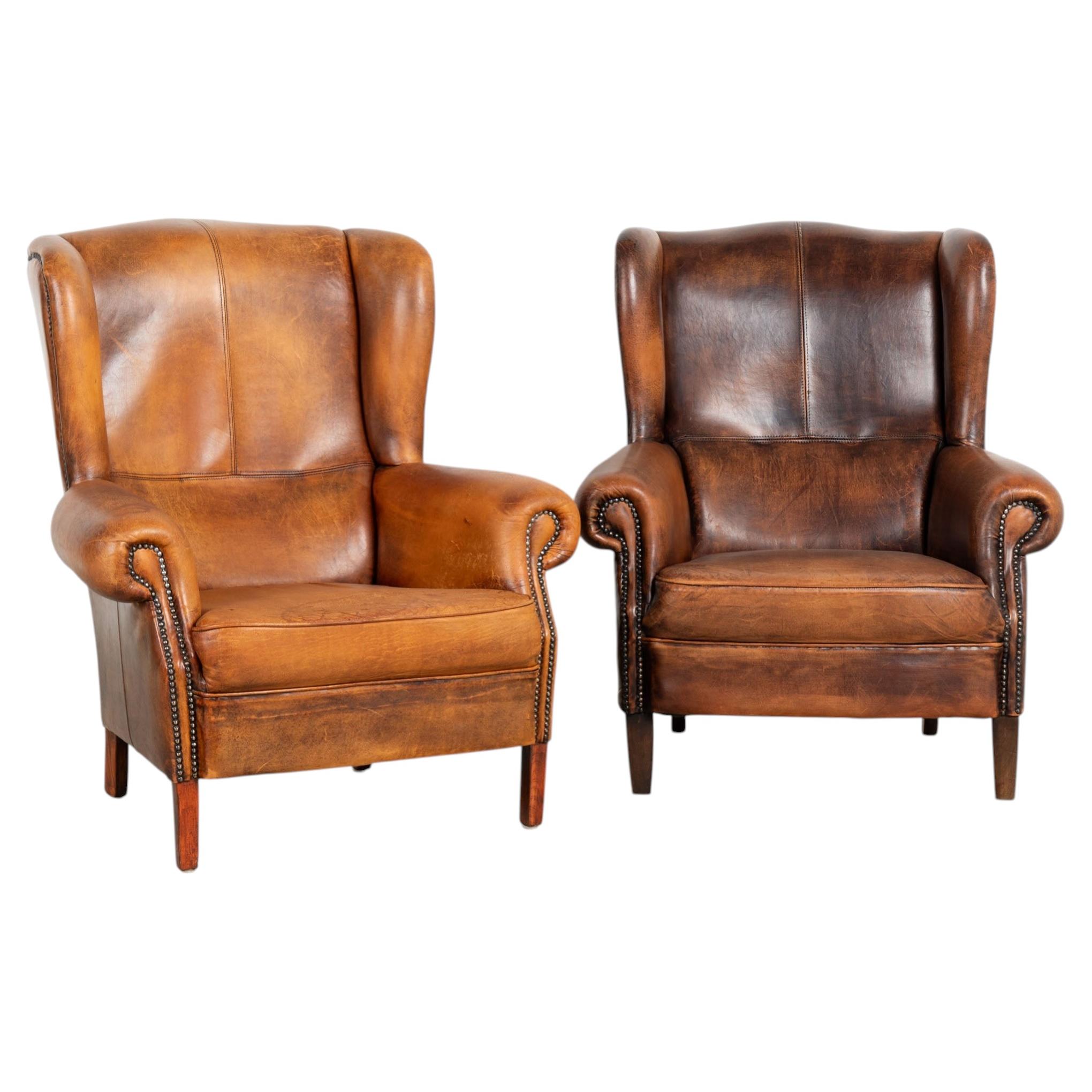 Par de sillones club daneses vintage del siglo XX, de cuero marrón y con respaldo alado en venta