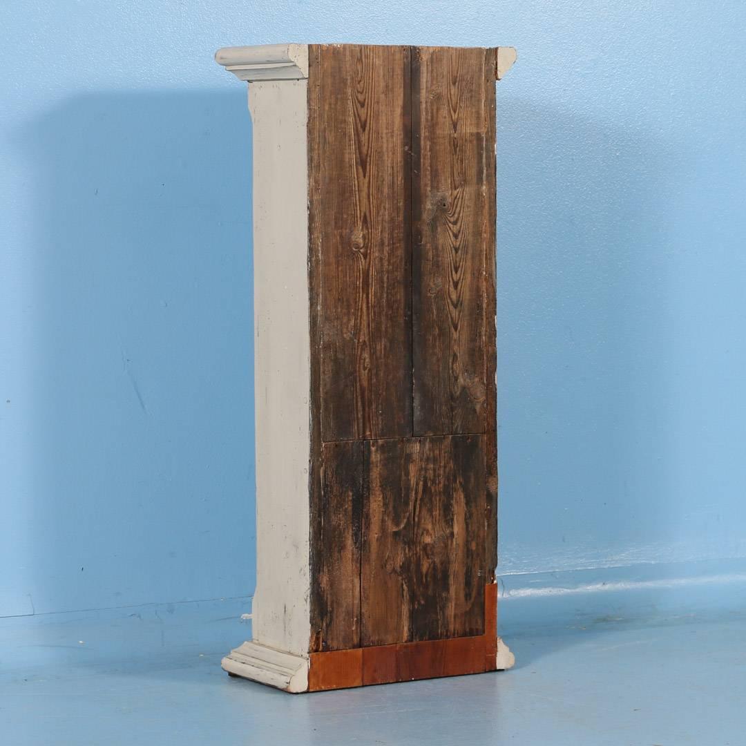 This small elongated Swedish cabinet features a single locking door, carved molding and a beveled edge on either side of the door. This cabinet would make a great plant stand or a display for art, or think about hanging it on the wall. It has a