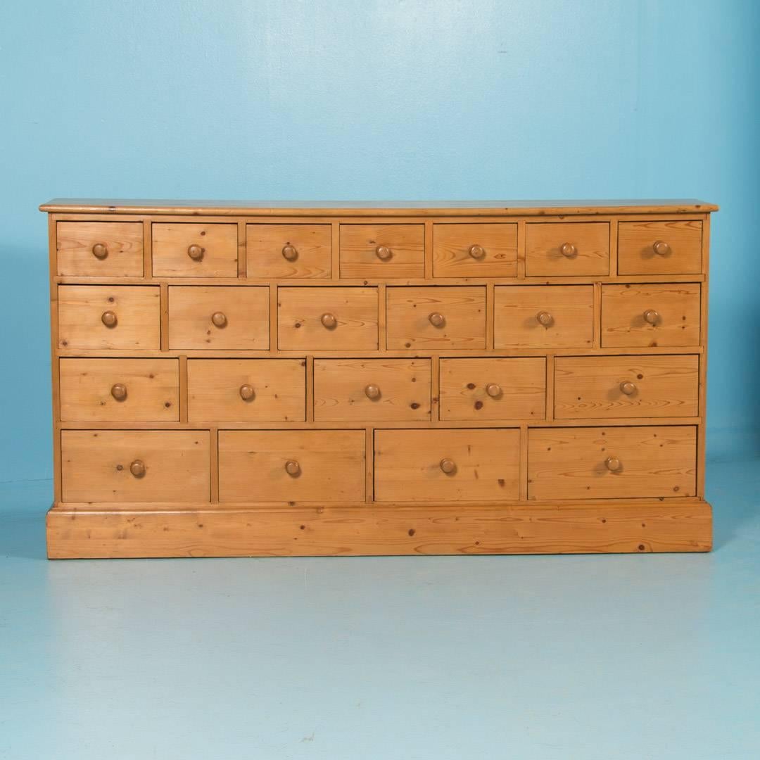 Wonderful antique pine multi-drawer cabinet from Denmark, circa 1880. This shallow cabinet made of pine has a total of 22 graduated drawers. Starting at the bottom, there are four drawers 14.5″ wide, then five drawers 11.5″ wide, then six drawers at