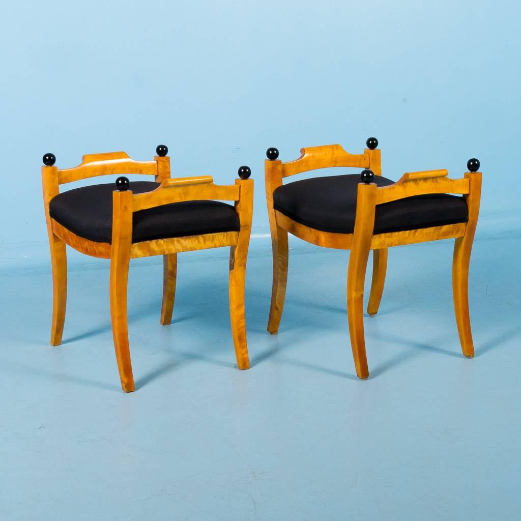 Pair of antique Swedish Karl Johan birch stools, circa 1860-1890. The 18″ high seats have new black upholstery that complement the yellow flame birch and painted black finials. Both benches are tight and sturdy. Please examine the enlarged/close up