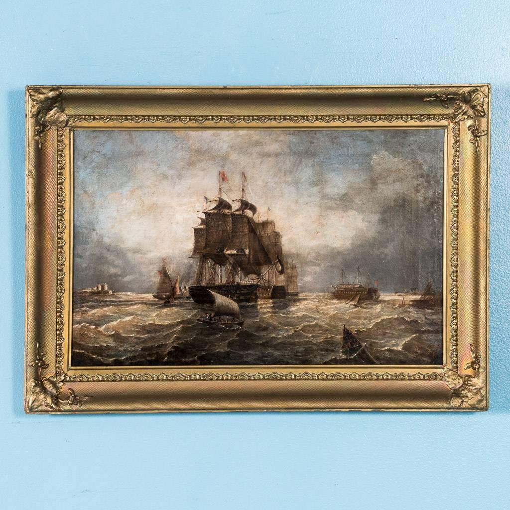 Antique English oil on canvas painting of war ships at sea, circa 1800-1840, in an ornate frame and signed in the lower right – J. Gouch, possibly J Gooch. The two main tall ships sail among smaller schooners, skiffs and a steamship, just off the