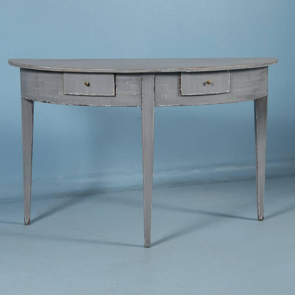 19th century demilune console table from Sweden, circa 1840-1860. Tapered legs and excellent craftsmanship accentuate this simple yet elegant antique Gustavian style half round table with two small drawers. Please examine the close up photos to