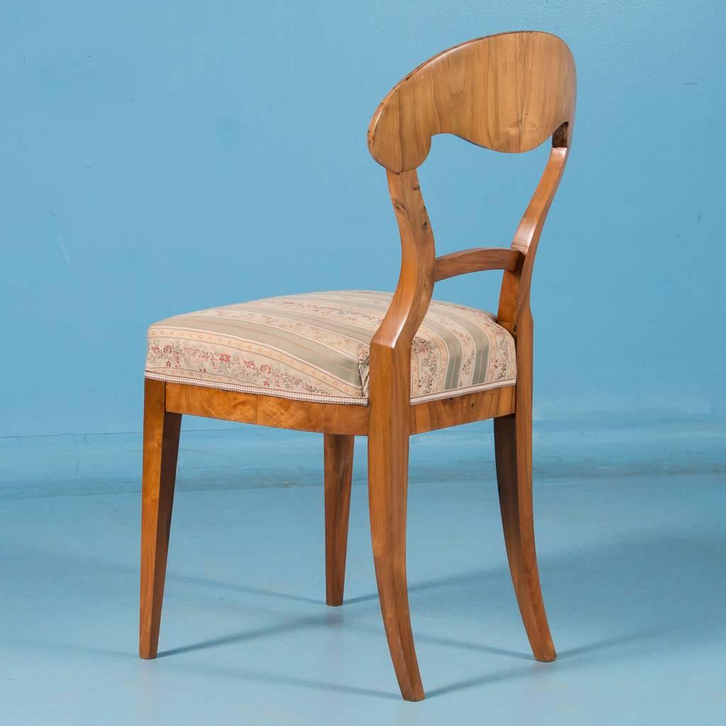 This antique cherry wood Biedermeier side chair is from Germany, circa 1840, and features a wonderful book matched burl back, an arched back splat and accents of burl on the apron. The upholstered seat is 19.5