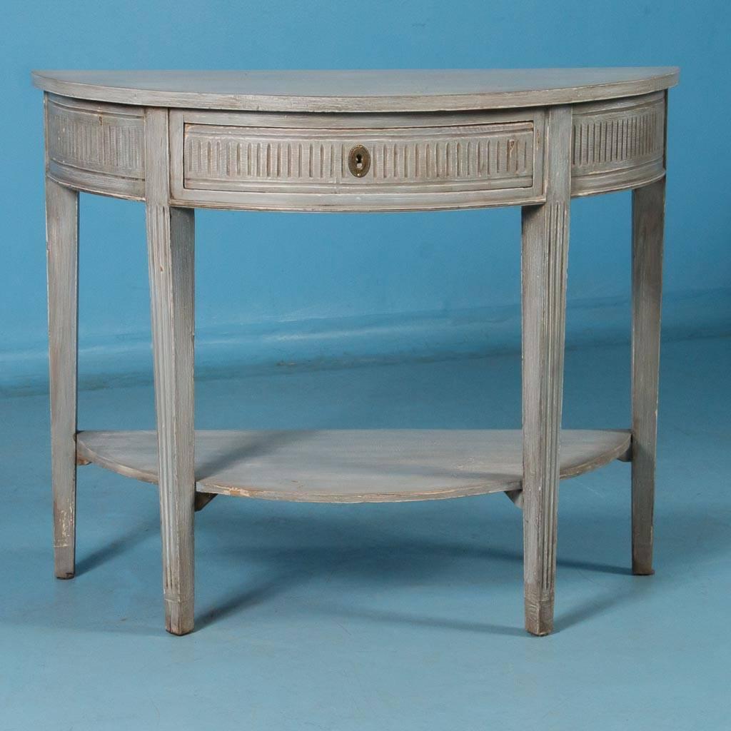 Antique pine Gustavian demilune console table from Sweden, circa 1880. The striking painted finish is an overall gray, but take a moment to examine the close up photos where the subtle layers of white and light gray are revealed in the gentle