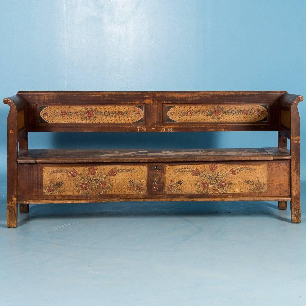 This country pine bench with it's original painted floral panels in a light yellow and a rich brown base color, has a hinged seat with lots of storage inside. A satin wax finish has been applied to enhance the colors and patina. Please take a moment