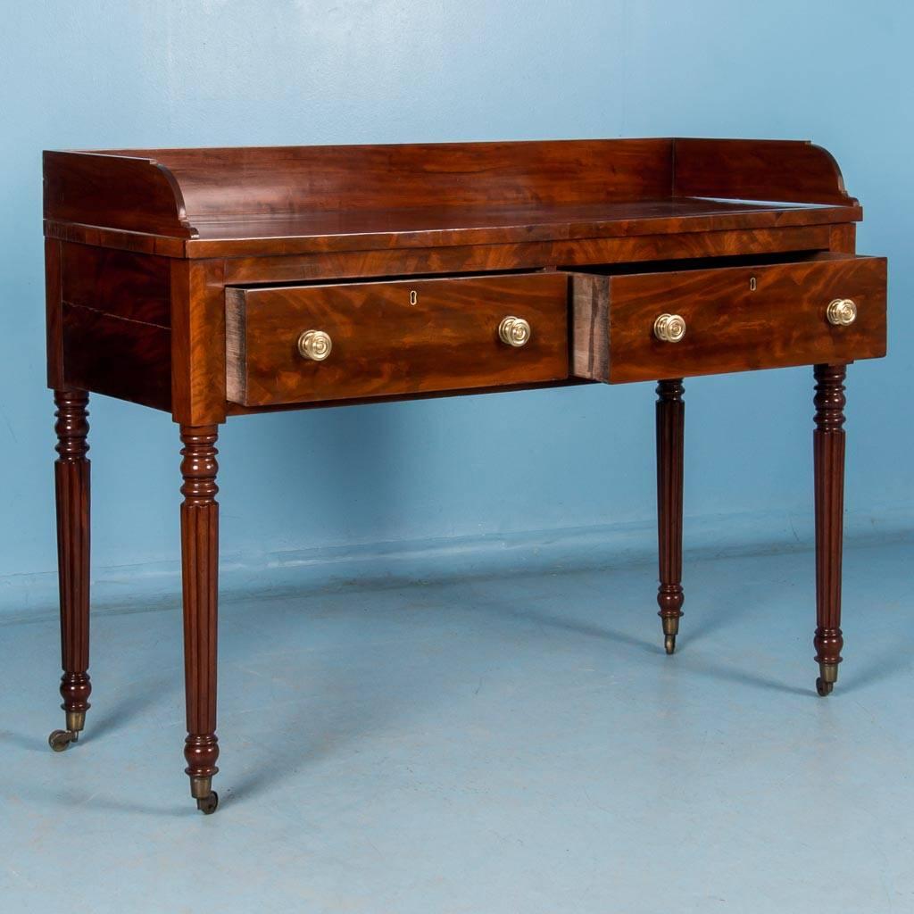 This American, 19th century flame mahogany sideboard, circa 1820-1840, features a pair of drawers, a low gallery backsplash surrounding the top and four turned legs with the original brass casters.

Scandinavian antiques imports containers from