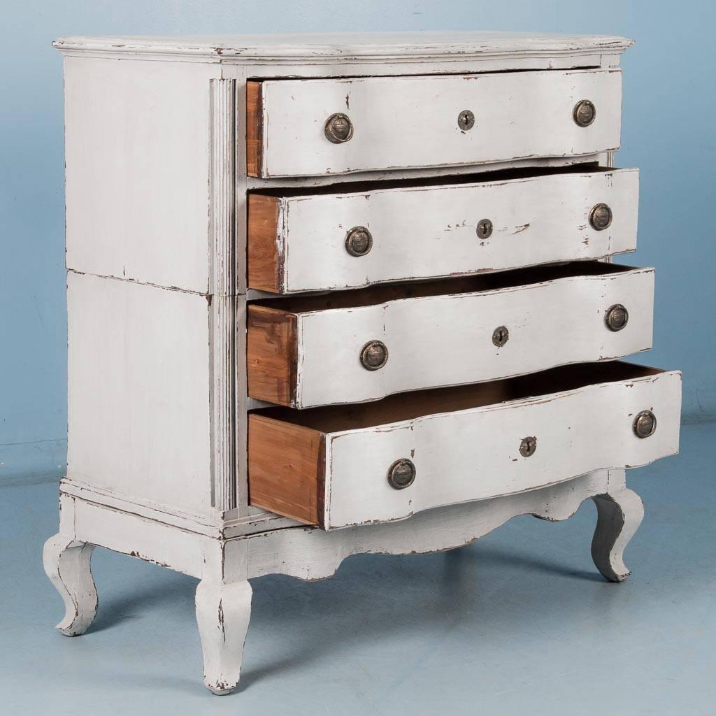 Antique Danish oak chest of drawers, circa 1760-1780 with a serpentine front and painted a pale gray. Made in two parts, the upper case with two drawers rests on the base with squared cabriole legs and another two drawers. The lightly scraped off