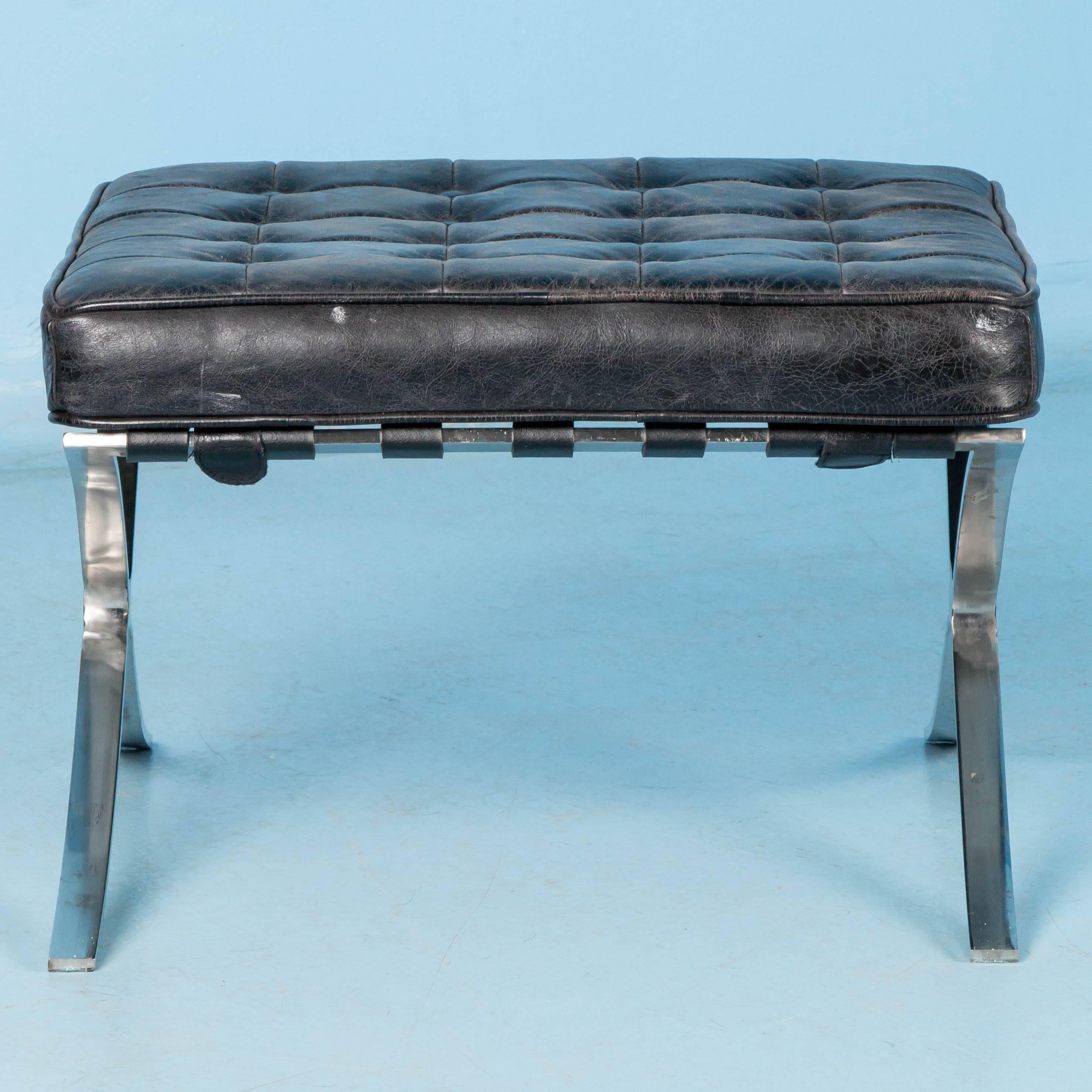 This Barcelona style black leather ottoman has a vintage look, chrome legs and a tufted seat. This matches a pair of Barcelona style chairs that are also available. Each of the chairs and the individual ottoman are sold separately.
