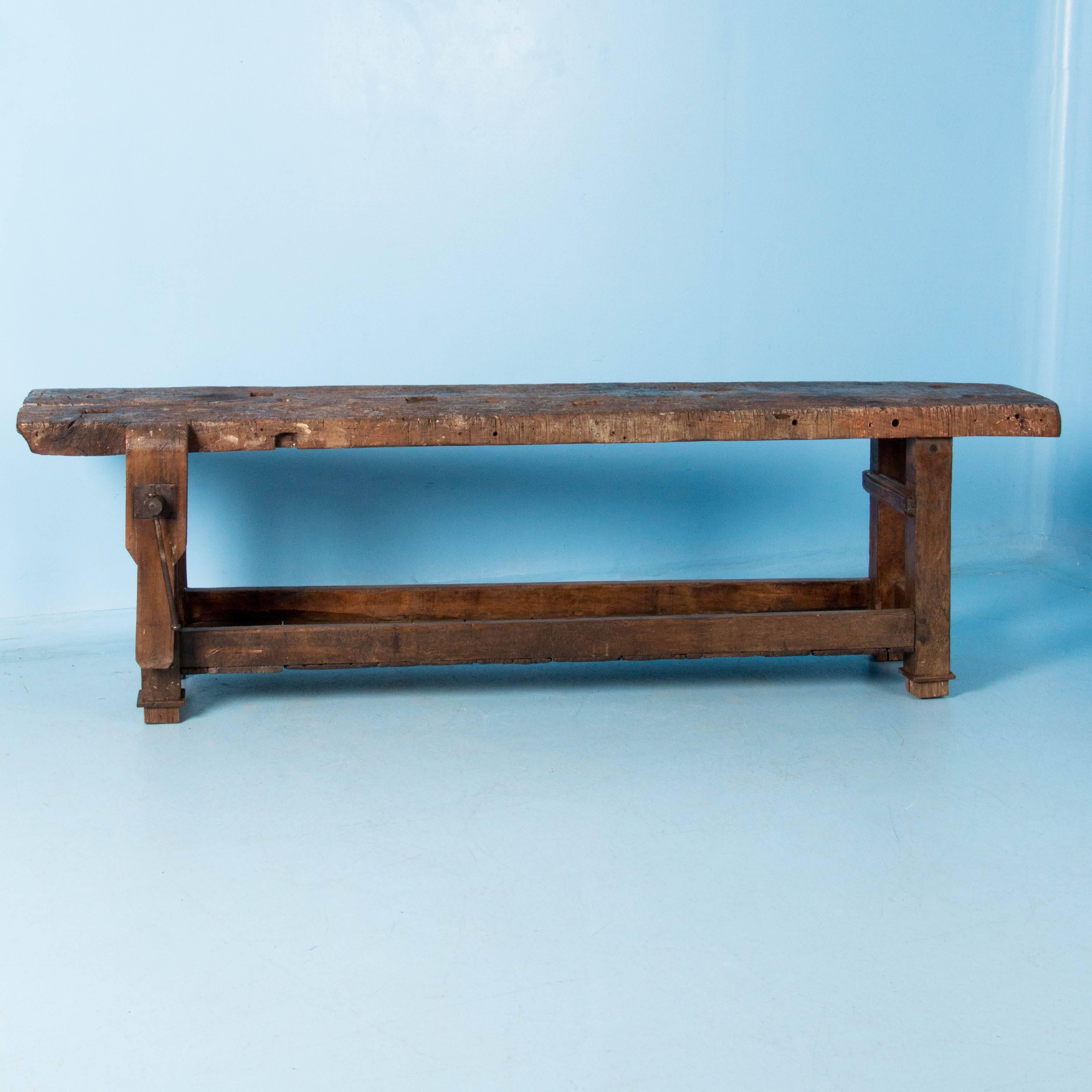 Well used for over a hundred years, this hardwood carpenter's workbench from France features a lower shelf and a single side vise with a metal screw. An additional 3