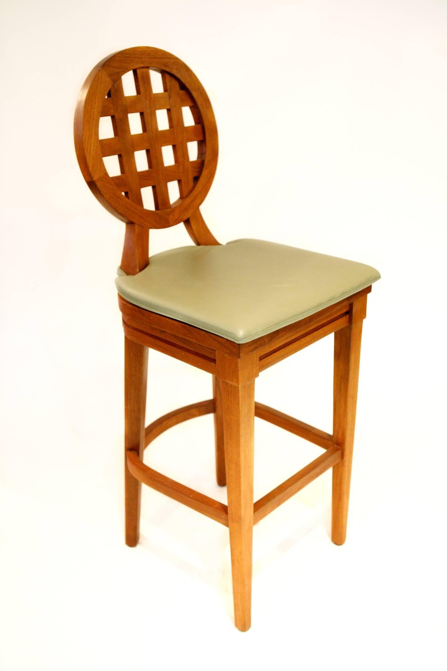 Set of three teak barstools with lattice oval back. Removable taupe leather cushions.