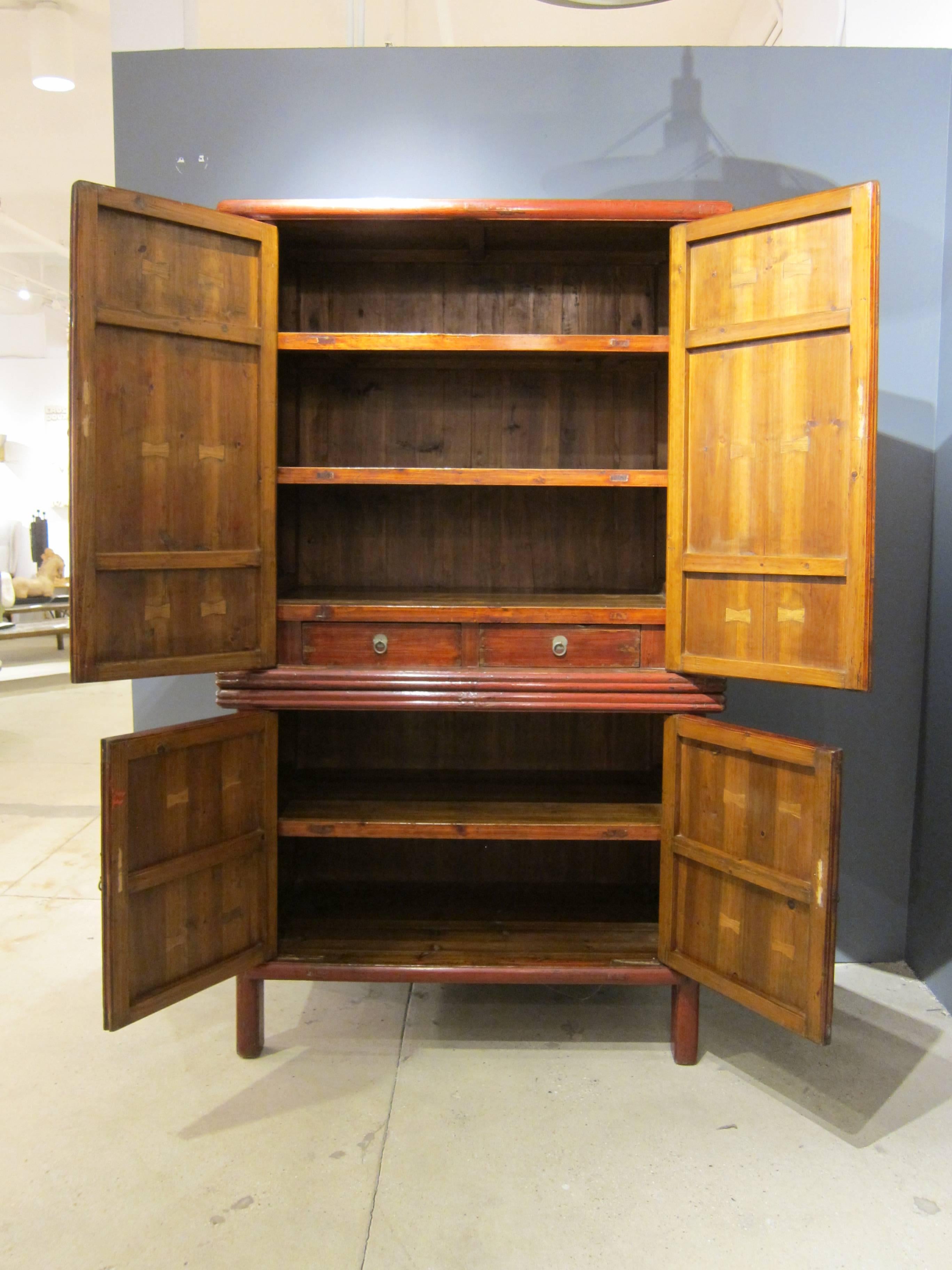 19th century two part Chinese tapered cabinet Armoire cedar / cypress wood with red lacquer panel doors, two drawers with five shelf's. This large cedar cabinet comes apart for easy moving and placement. Condition is excellent very good condition
