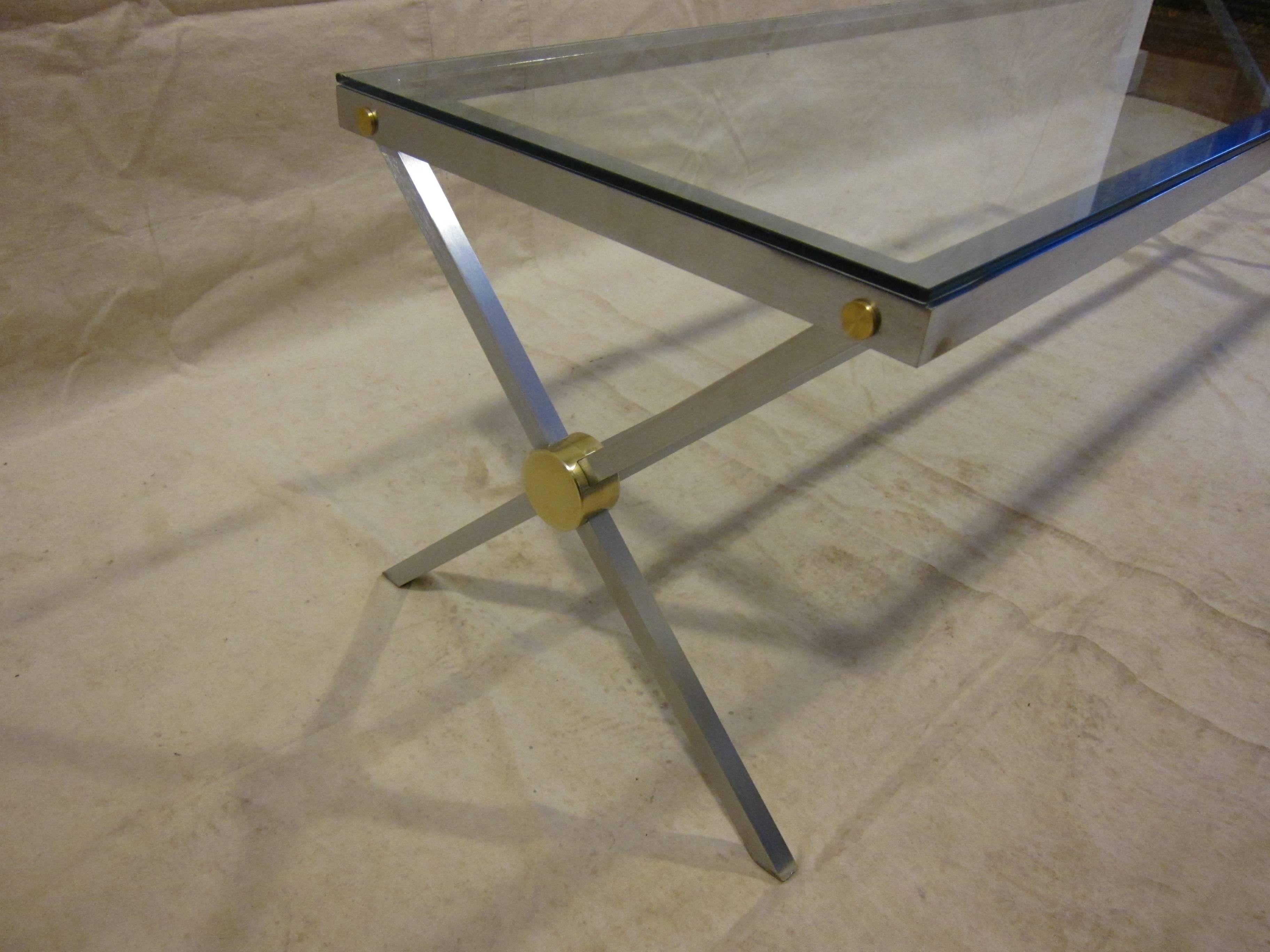John Vesey cocktail table X-base with brass detail and brushed steel. Glass top. Very good condition.