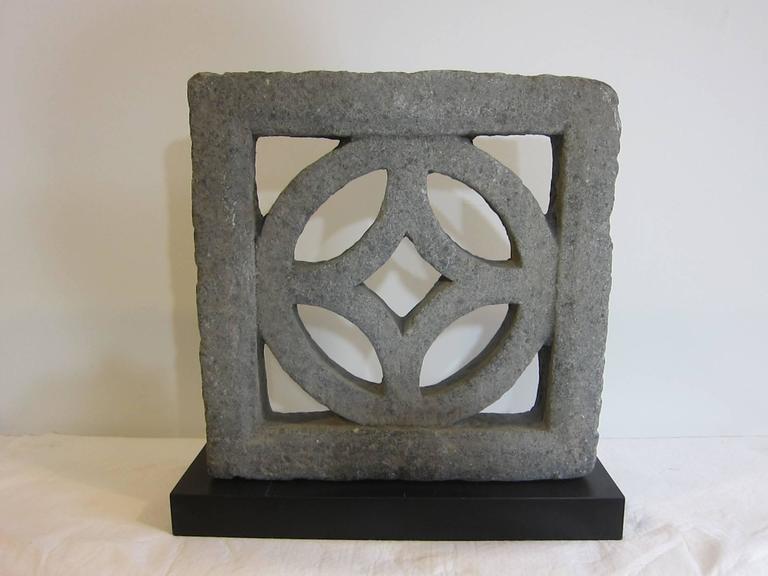 Stone carved symbol for money. Chinese ancient symbol for money. A solid carved block of stone 3.5 inches thick. Possibly used as a window grate. This stone carving can be used with or without the stand, inside or outside.  A stand of black laminate