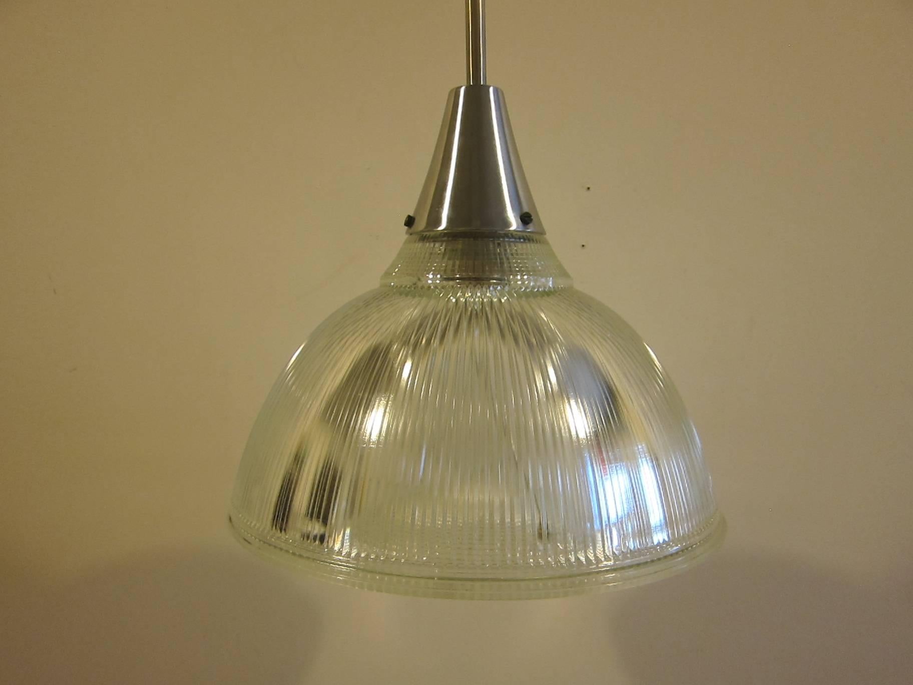 1950s Holophane pendant lamp in excellent condition. Pair available.
Perfect Holophane shade complete with inner shell diffuser. New wiring.
Fixture is original, complete with drop down pole and plate cover. 300 watt capacity. 
Holophane label to