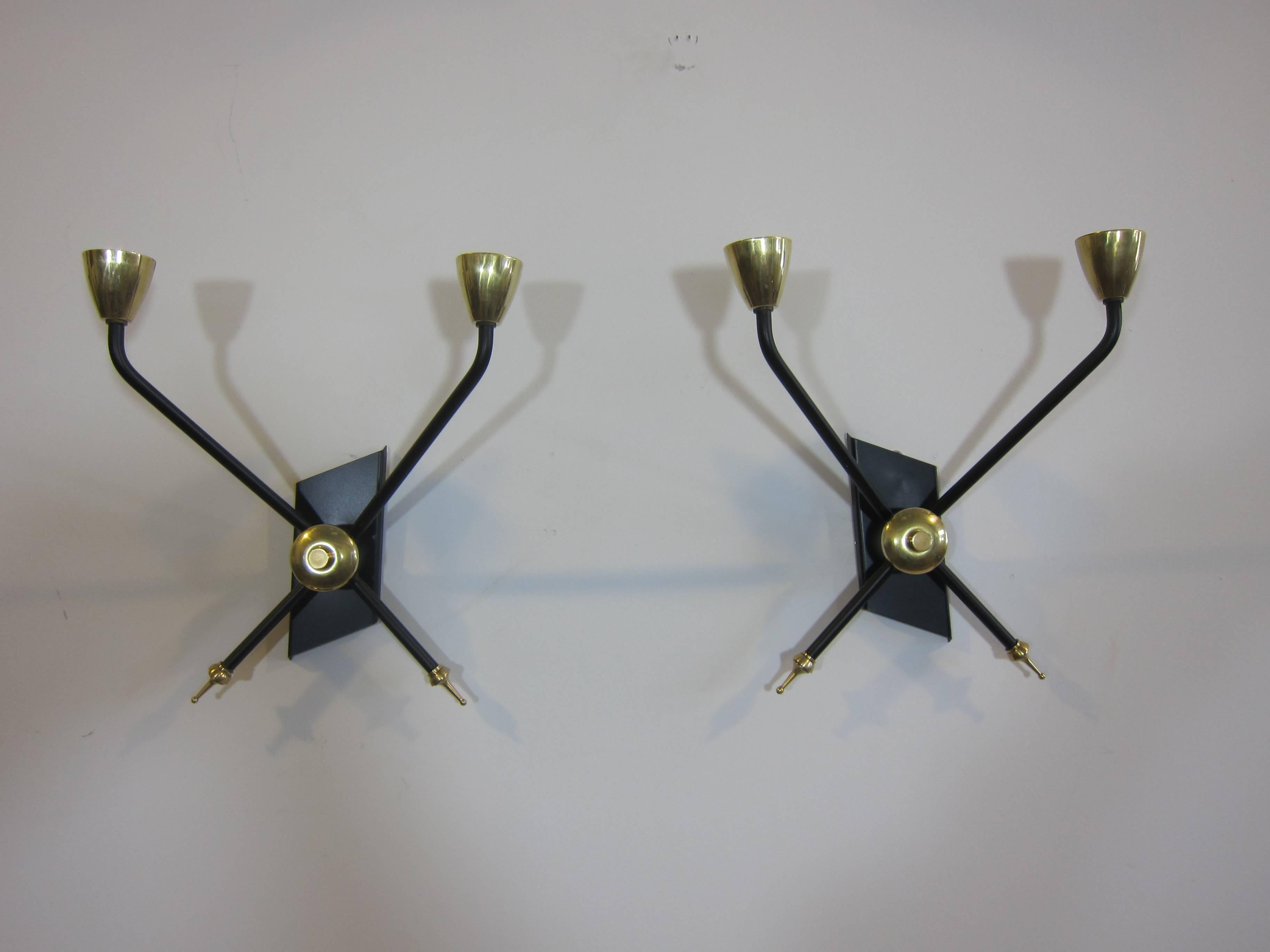 A pair of French Mid-Century sconces attributed to Arlus with directional left and right sided mounting plates. Powder coated iron with brass, France, 1950. Very good to excellent condition.