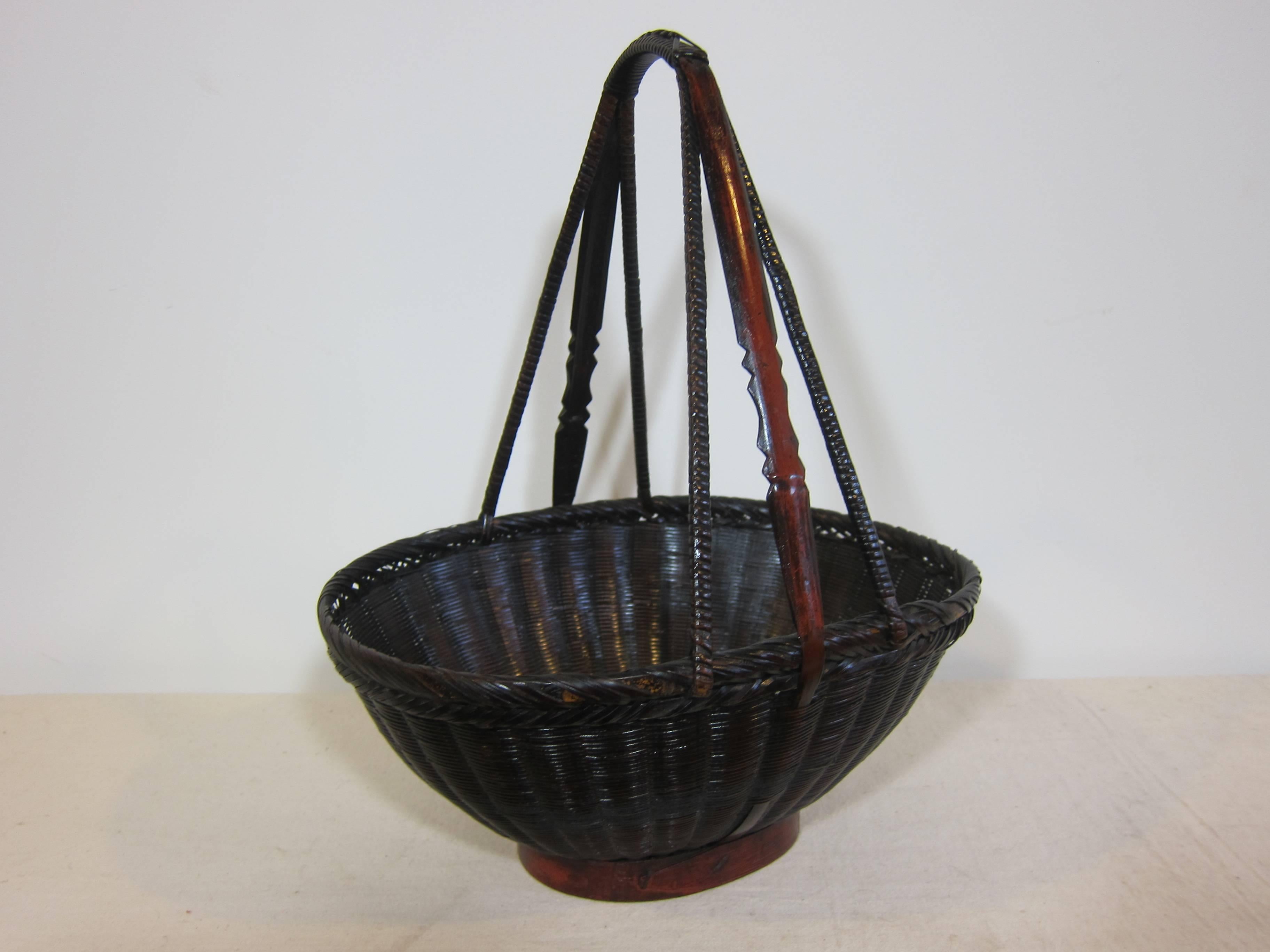 19th century antique woven basket. Decorative basket. This is an actual antique market basket in very good condition. Woven reed, bamboo, and wood. Having intricate detailed work, with carved handles.
    