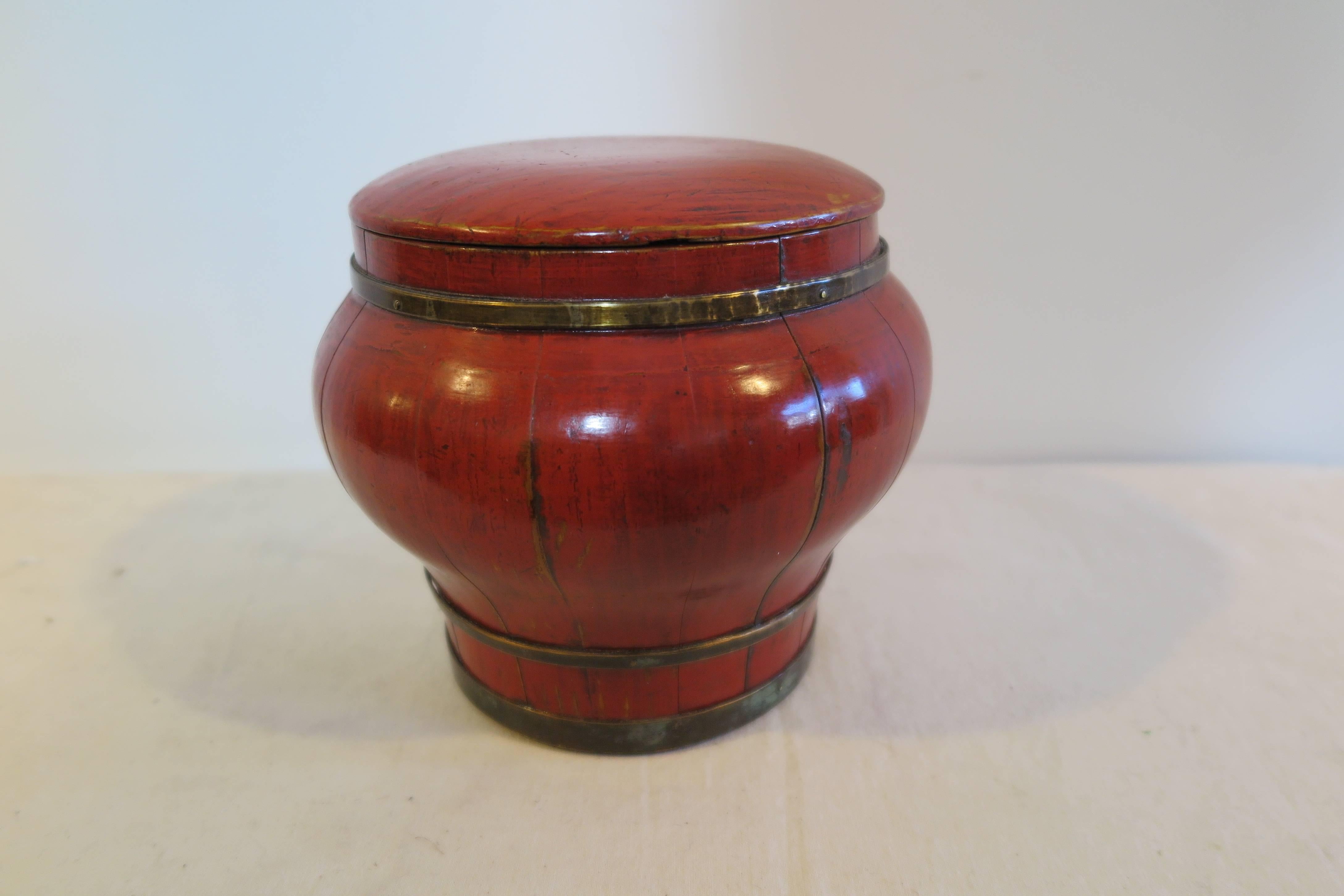 A 19th century Chinese wooden bowl with red lacquer and bronze banding. Solid pieces of wood sculpted into meticulously matching pieces that section together to create this wonderful curved round shape. The pieces of wood are held together by the