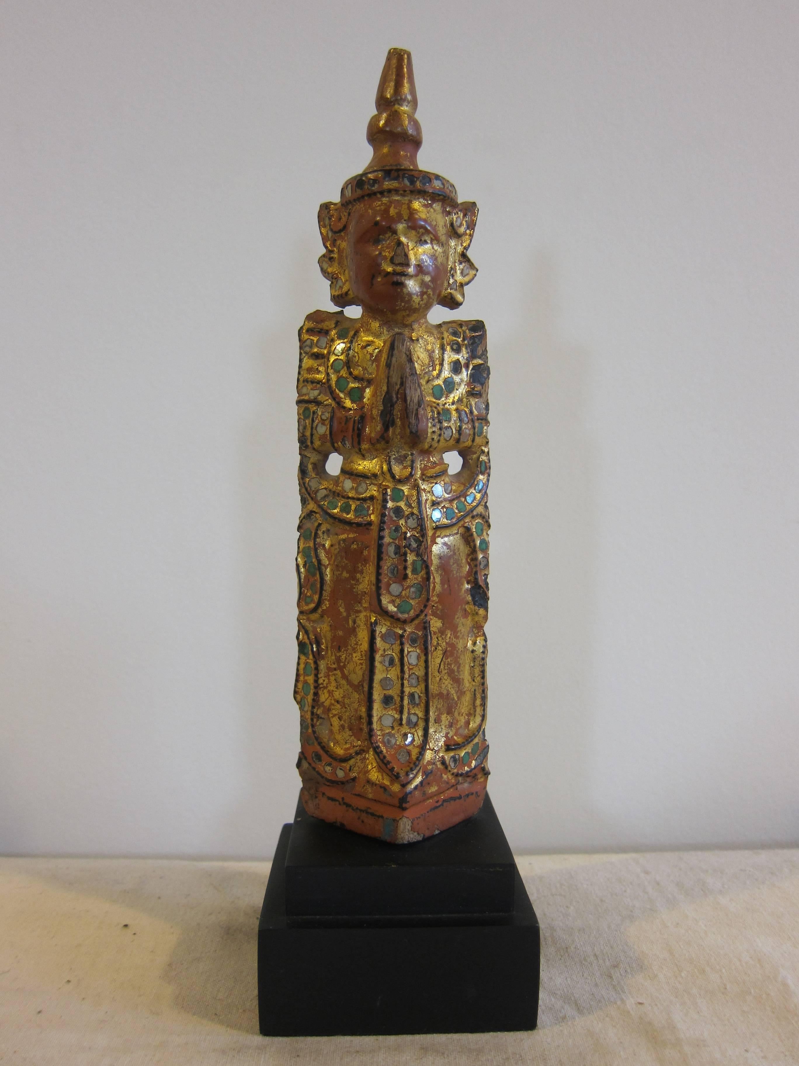 A 19th century Burmese / Thai Theravada Buddhist prayer angel carved teak wood with dry lacquer, Thayo with jewel glass and gilding. In the welcoming position with hands together at chest pointed up. This is also considered a prayer stance. This
