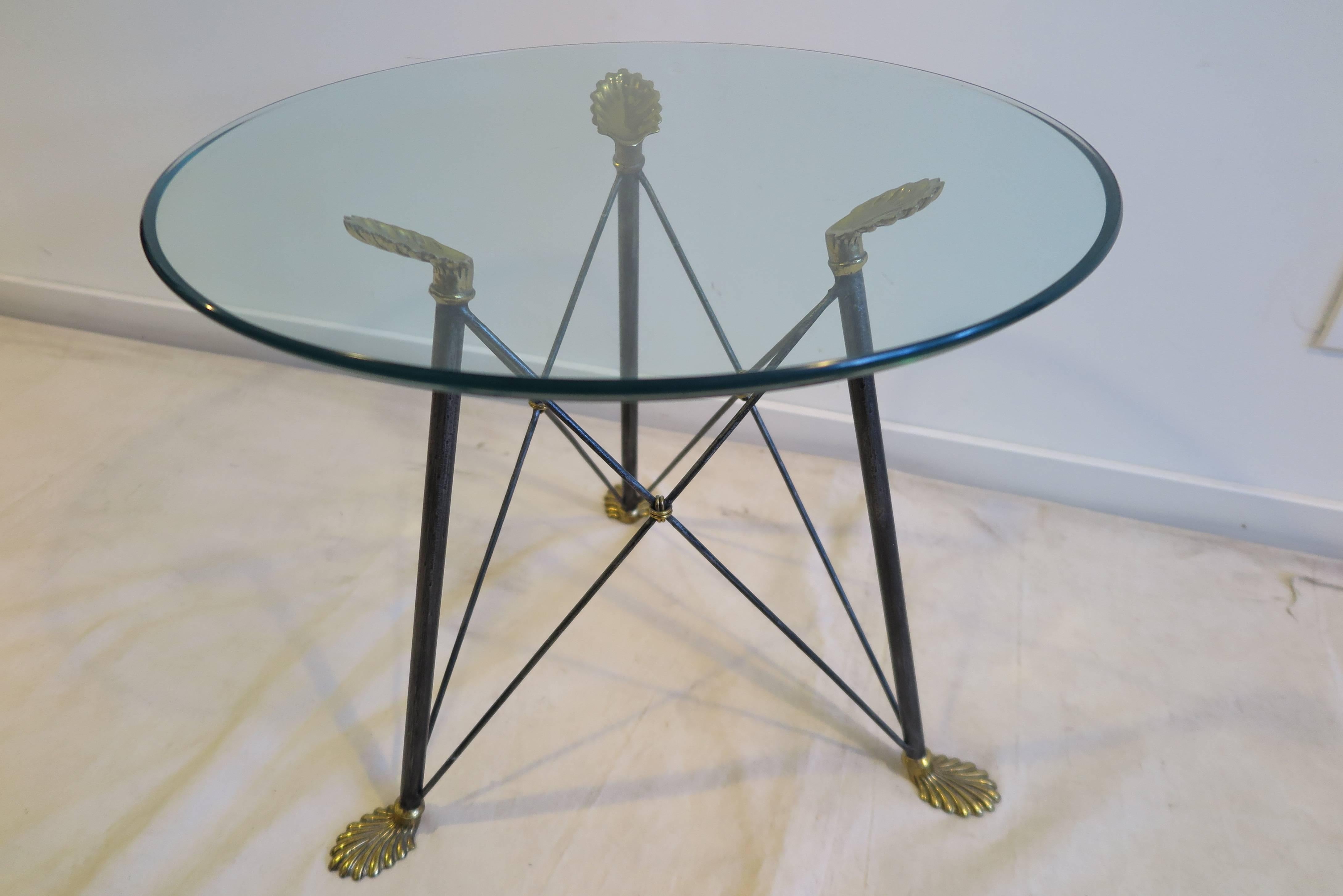 Mid Century French regency style glass side table, cocktail table, end table. Glass top with steel ‘X’ frame base with brass feet and hands having brass knot details in the style of Jansen. Light scratches to the glass, Very good condition. 
