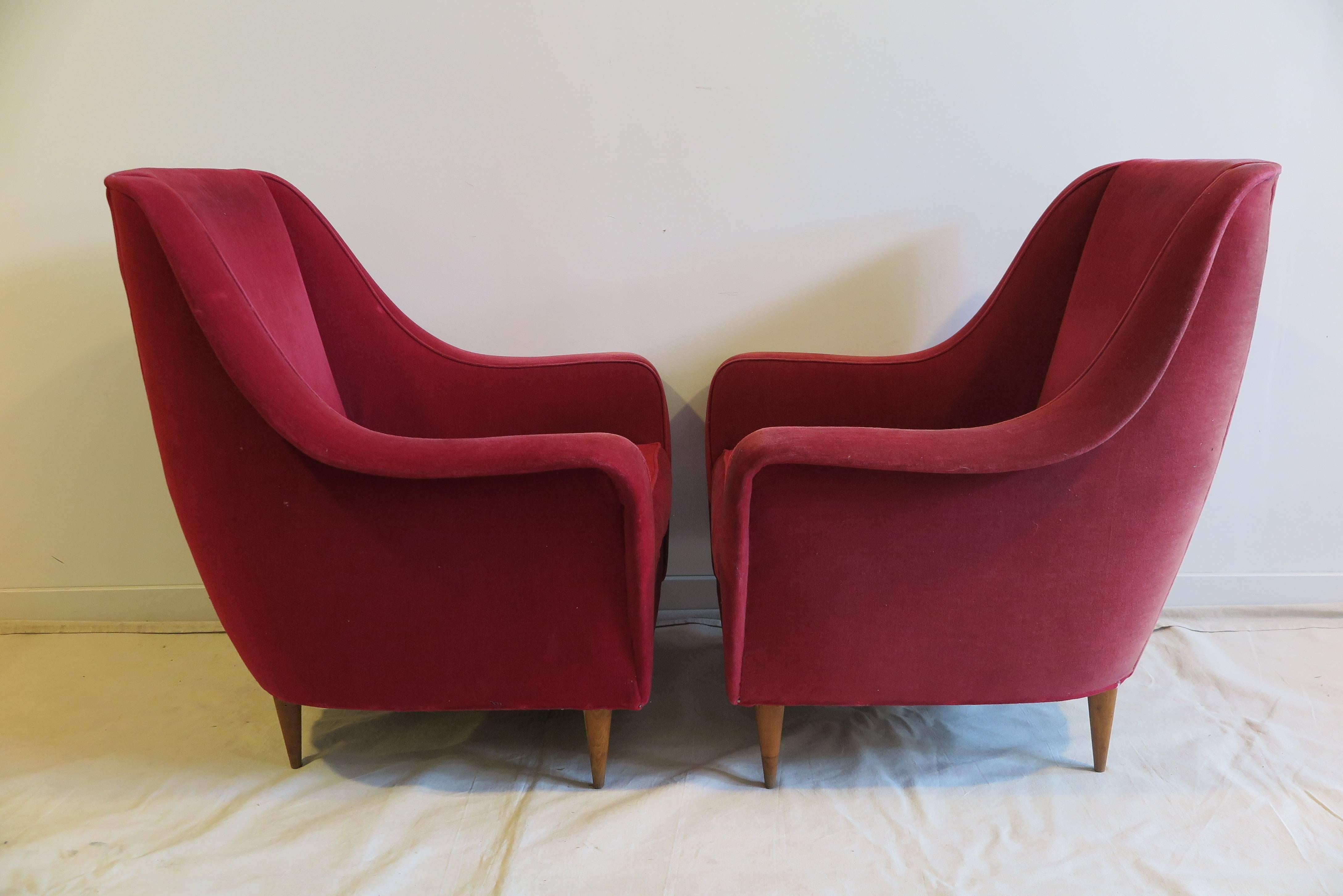 Pair of Italian Mid-Century club chairs lounge chairs in the style of Ico Parisi. Exceptionally sculpted on minimal wooden legs. Extremely comfortable. Upholstery is faded, new upholstery recommended.