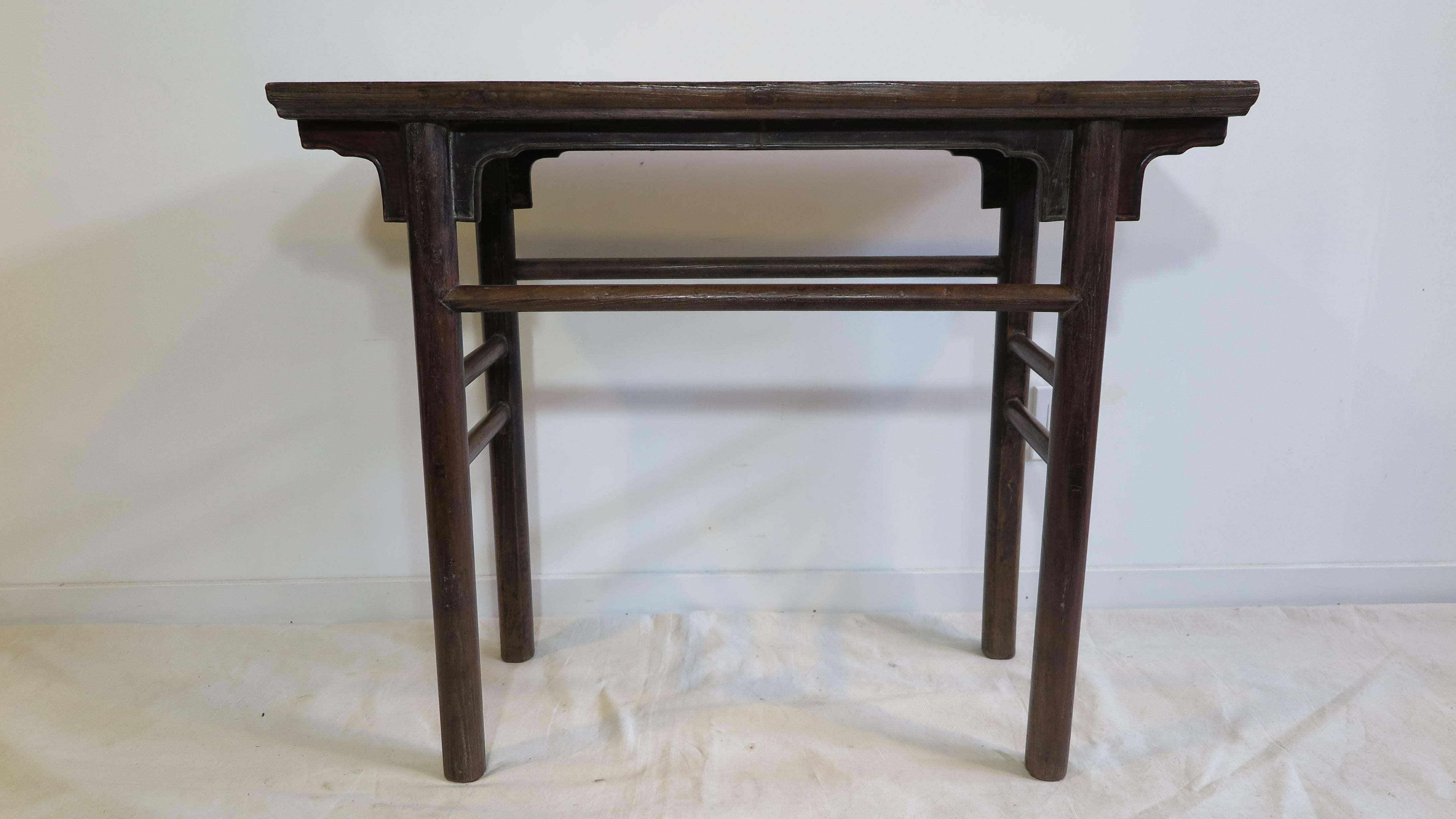 A 19th century Chinese console table, also referred to as a wine table.  Old growth Northern elm wood. Very solid. Having apron with spandrels, and uniform cylindrical round legs. This piece has a both a rustic appeal from natural aging and the