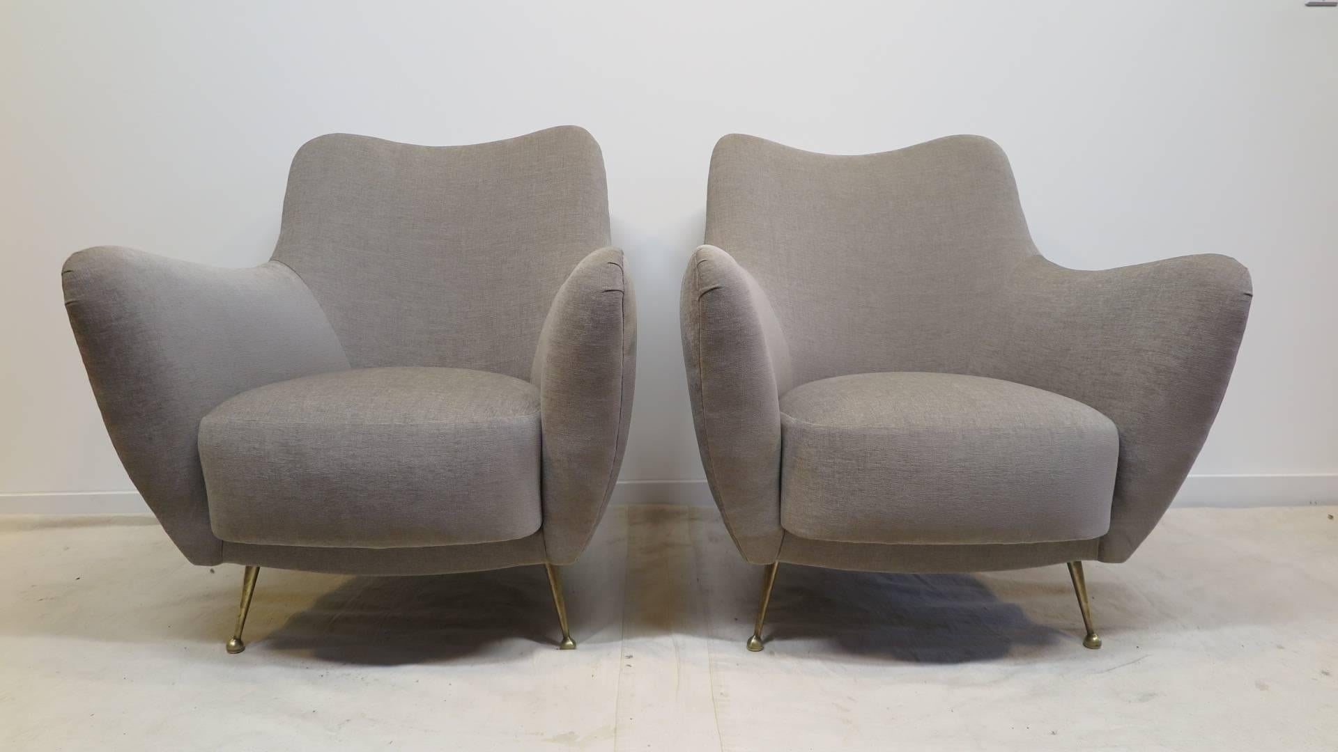 A pair of 1950 Italian sculpted lounge chairs, attributed to Giulia Veronesi, Perla chairs for ISA Bergamo, with solid brass legs supporting a contoured shaped seat. Very comfortable in excellent restored condition. 