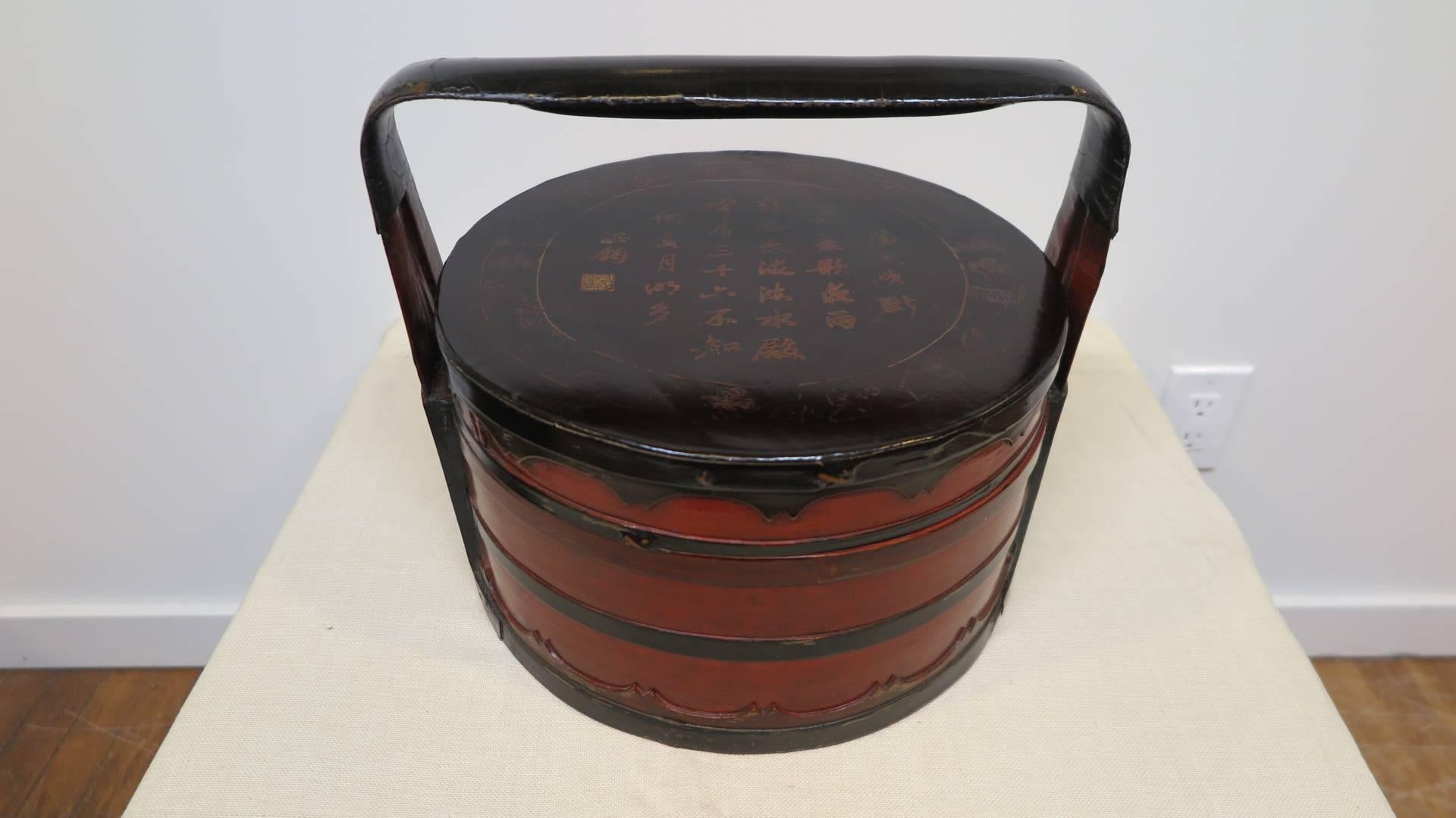 A 19th century Chinese food box.  Woven & turned bamboo with fruit wood crafted into a food box container.   Associated with serving Dim Sum.  Decorated in lacquer with gilt Calligraphy telling a story surrounded with (Shrivastava) eternal knots