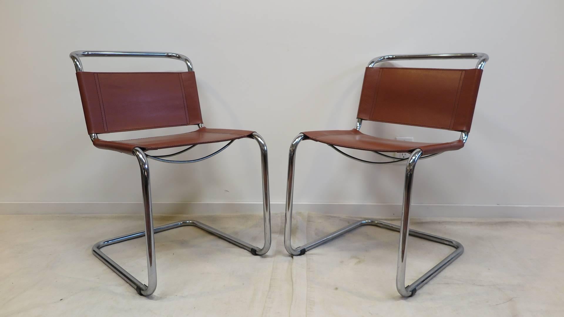 A pair chairs designed by Mart Stam for Fasem.
These chairs have a cantilevered tubular metal frame with cognac saddle leather seating and backrest. They are in very good condition. 
 