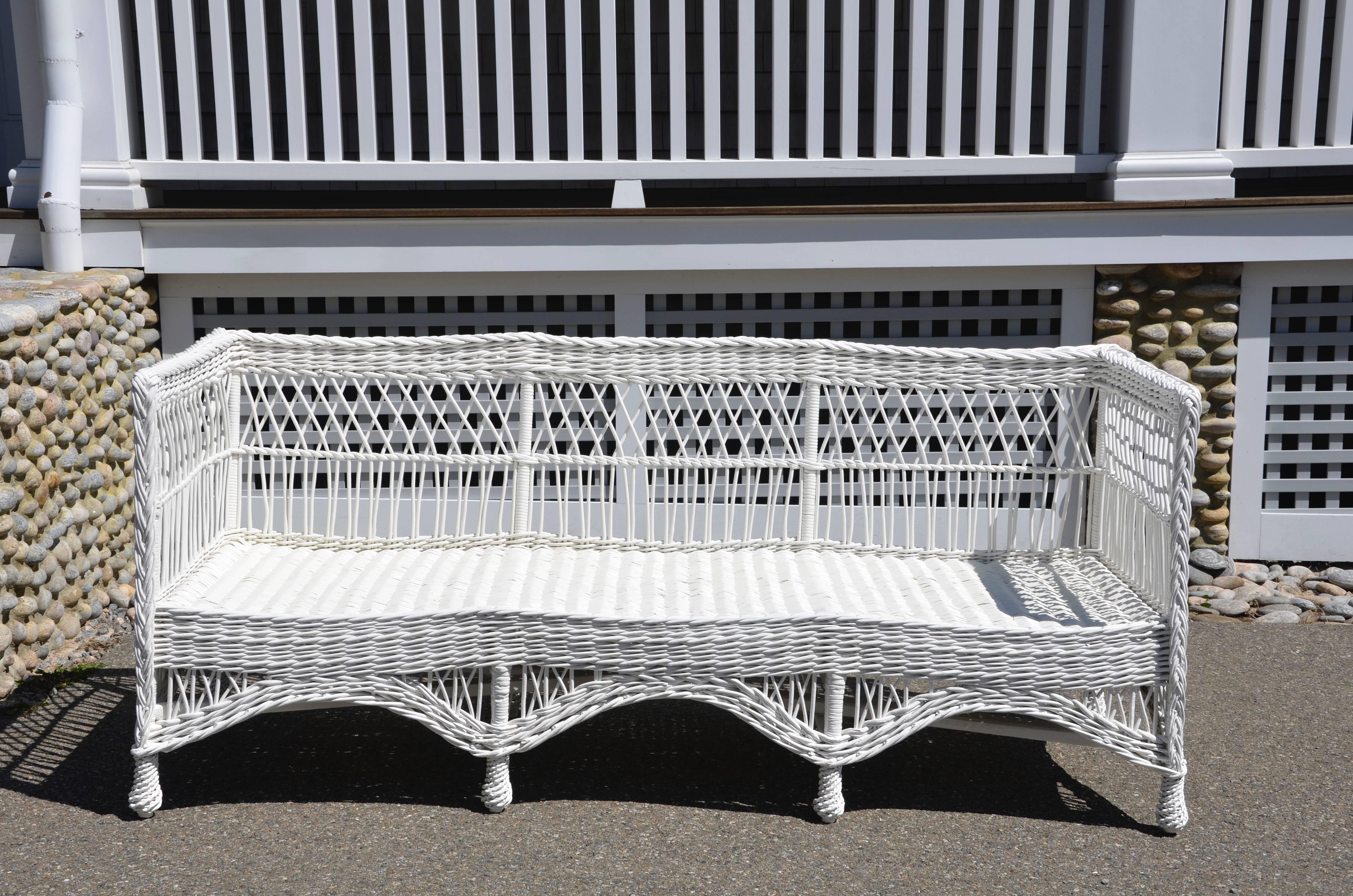 Antique wicker daybed woven of willow and freshly painted white.