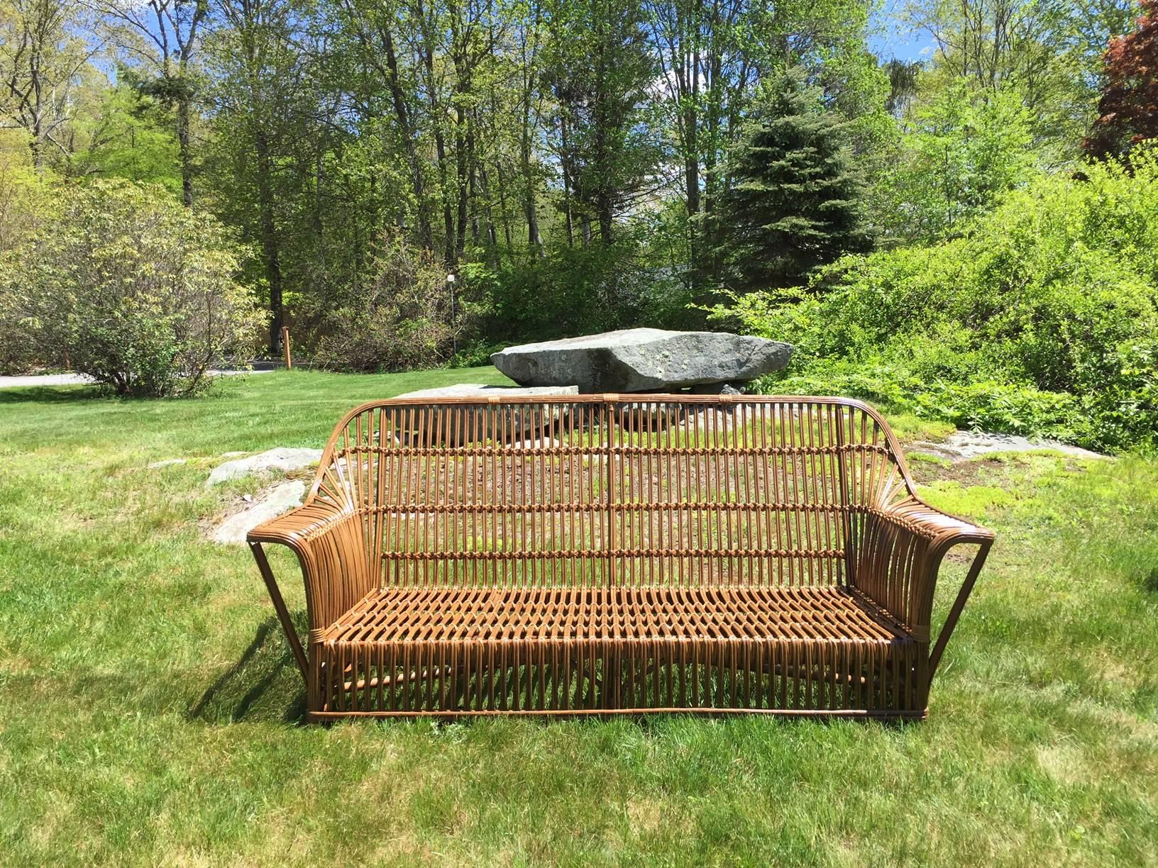 Antique Ficks Reed rattan sofa in natural finish. Beautifully restored stick wicker sofa measuring 75