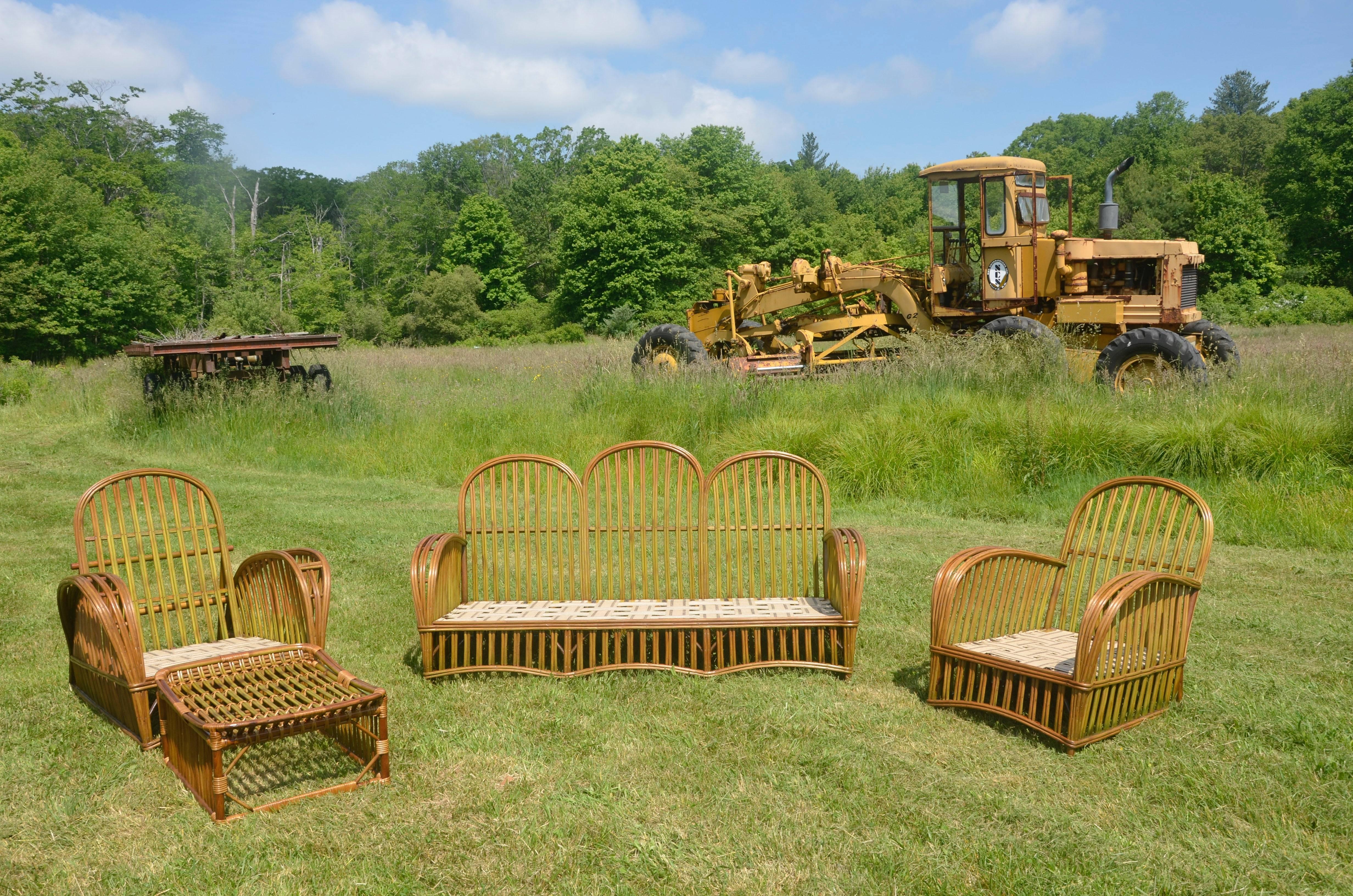 Beautiful vintage Heywood-Wakefield stick rattan five piece set in original factory finish. Coordinating table pictured is included with the seating. Larger of the two chairs reclines.  Beautiful original finish.