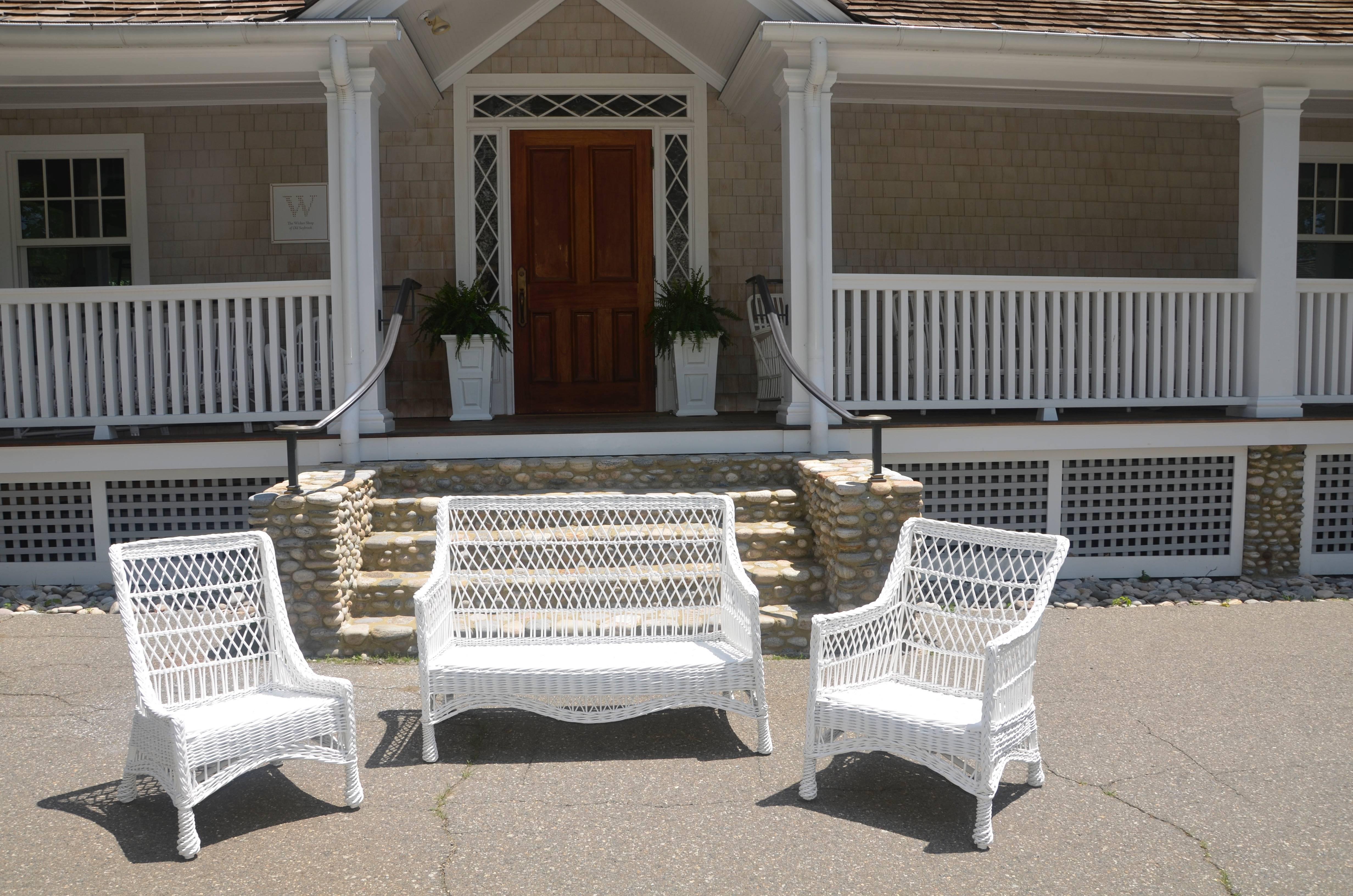 Small-scale three-piece antique wicker set woven of willow and painted white. 

Measures: Settee measures 45