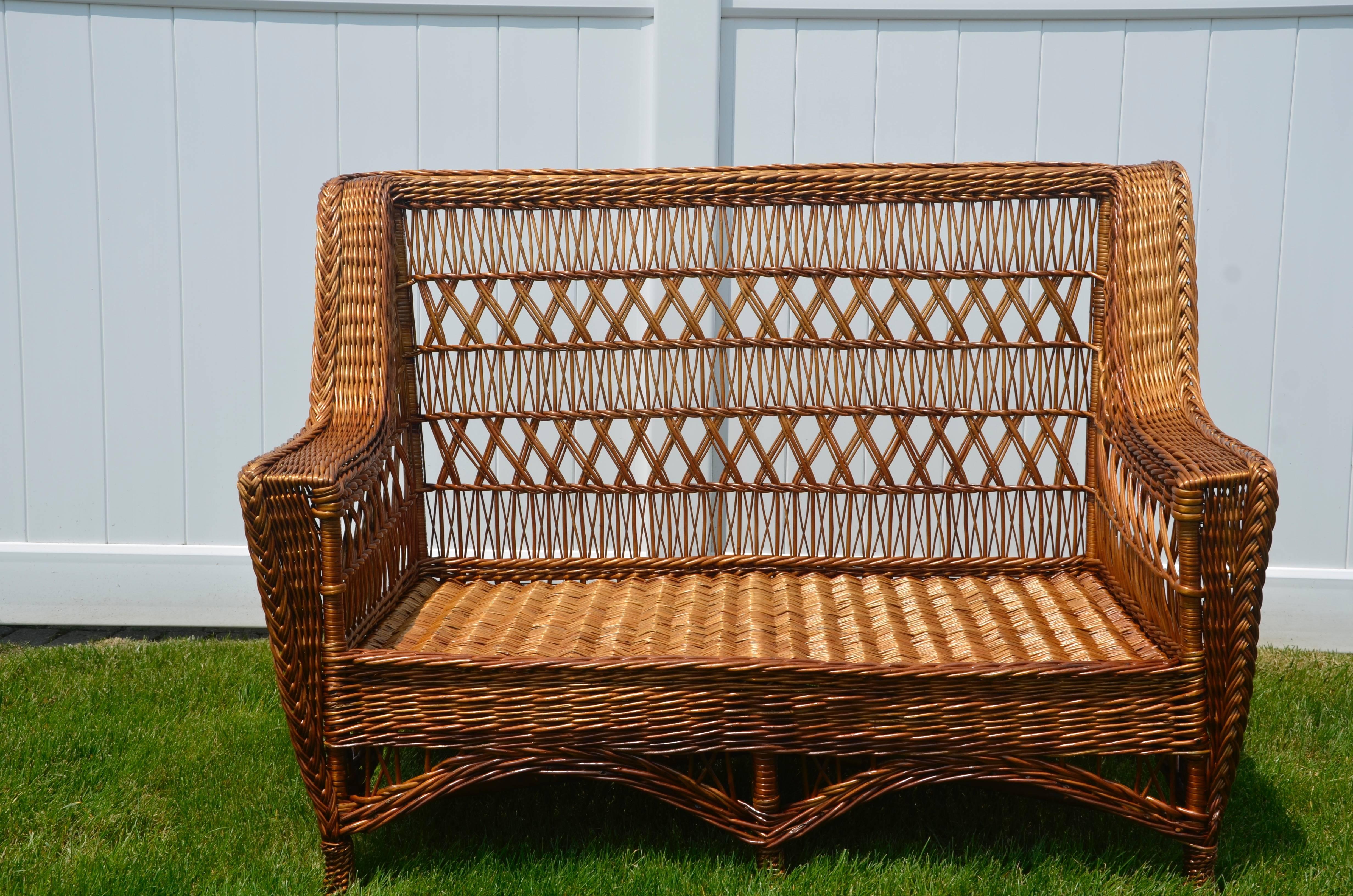 An immaculate, antique willow settee made by Paine Furniture implementing the triple cross pattern. This is a scarcely seen item in outstanding condition.