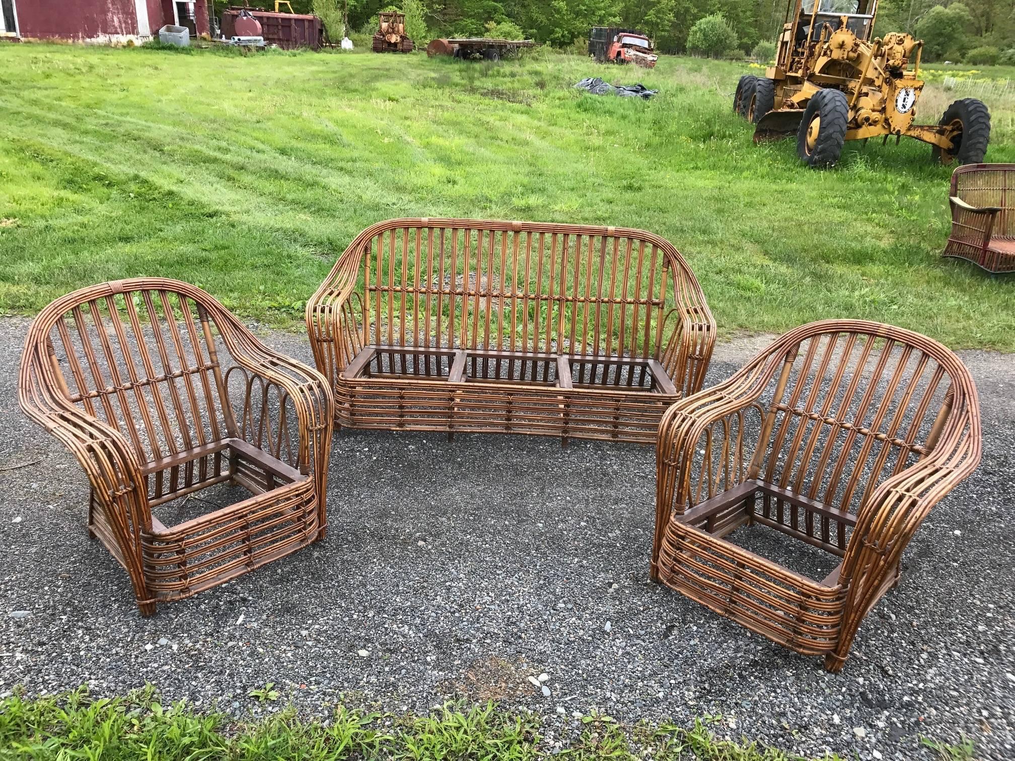 Unusual three-piece stick rattan set comprised of one sofa and two chairs. Box spring seats are presently being recovered at the upholsterer. This set binds three rattan strands instead of the usual two which provides interest and strength. Sofa