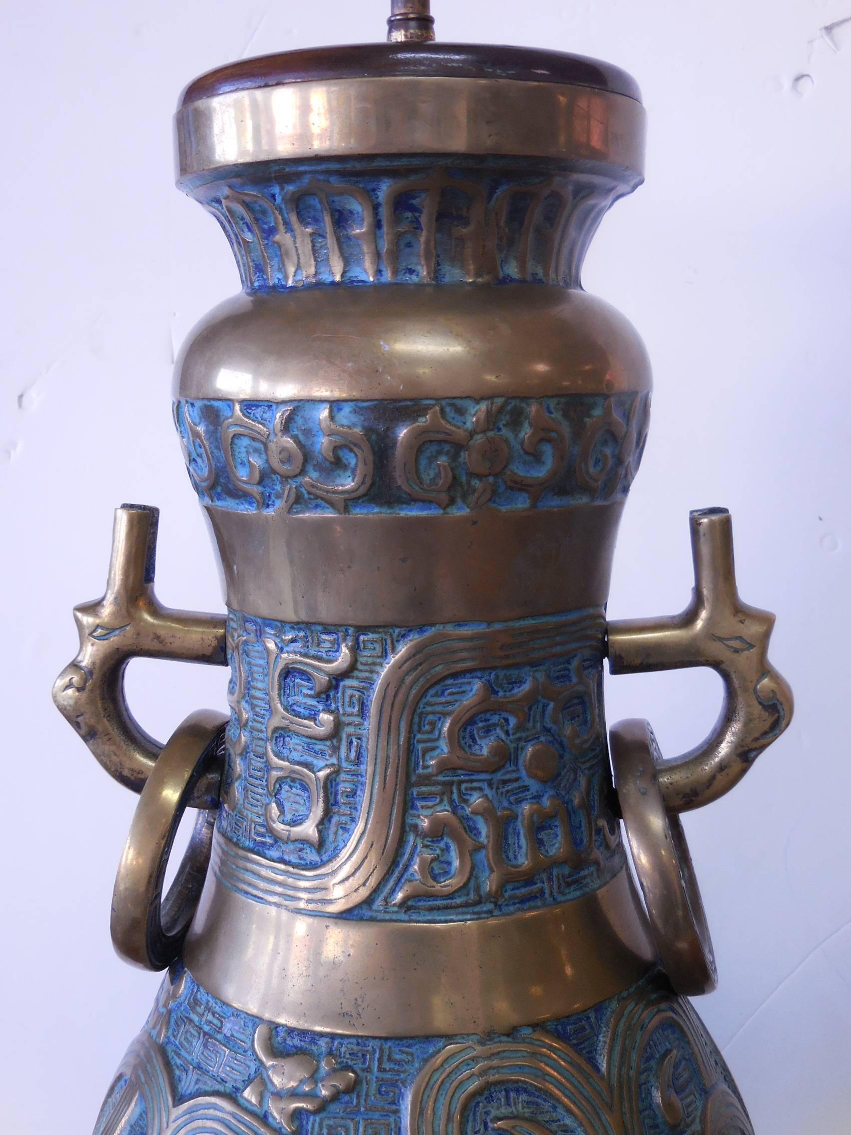 Stunning pair of lamps. Heavy brass casting with beautiful turquoise enamel. Large rings with Greek key design flank the large urns. Signed as pictured. 22