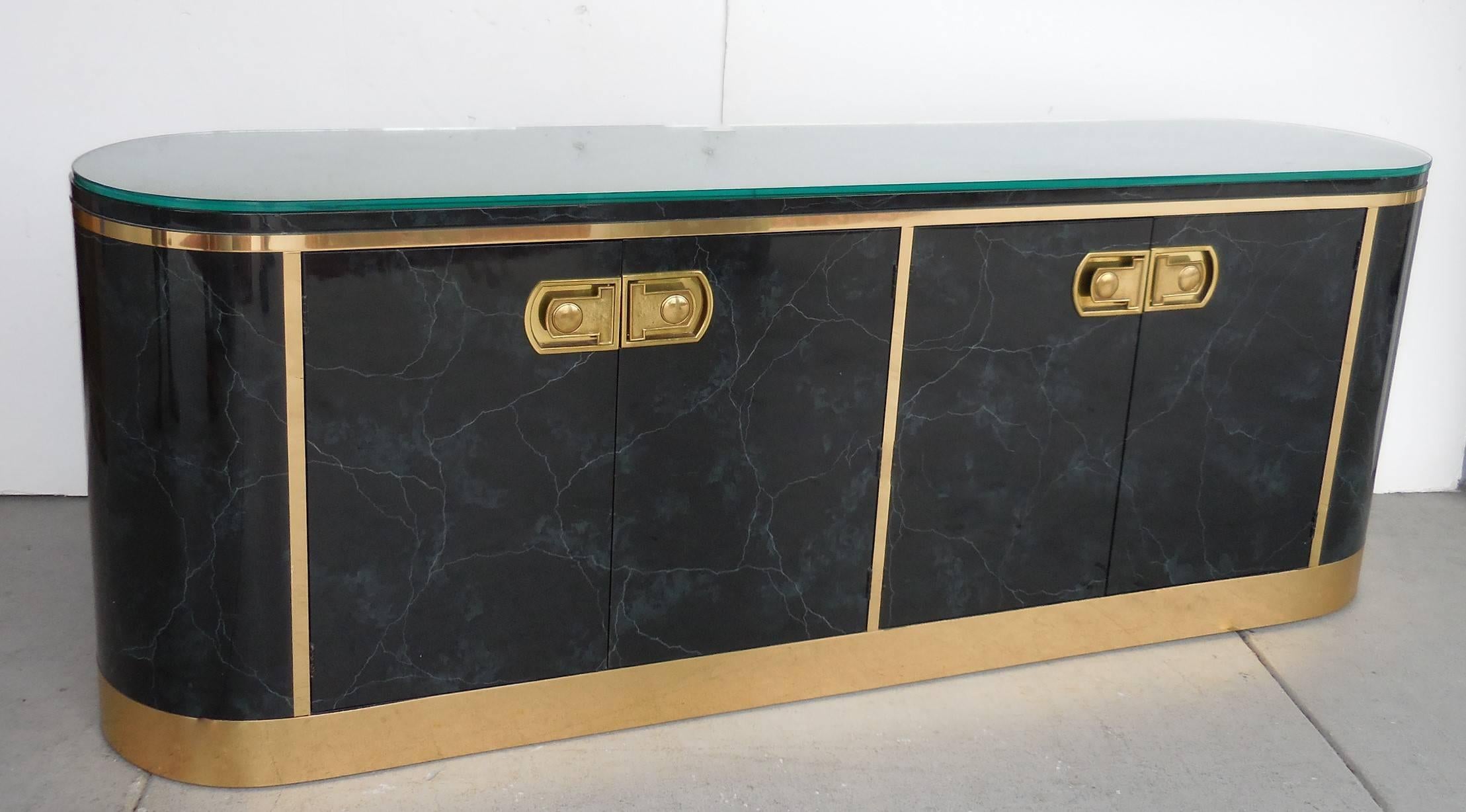 A rare lacquered console with radial ends. Brass pulls and trims. The lacquer is meticulously done to resemble marble, very effective. Includes a half inch thick fitted glass top. Signed on back. This cabinet has four doors that open to reveal four