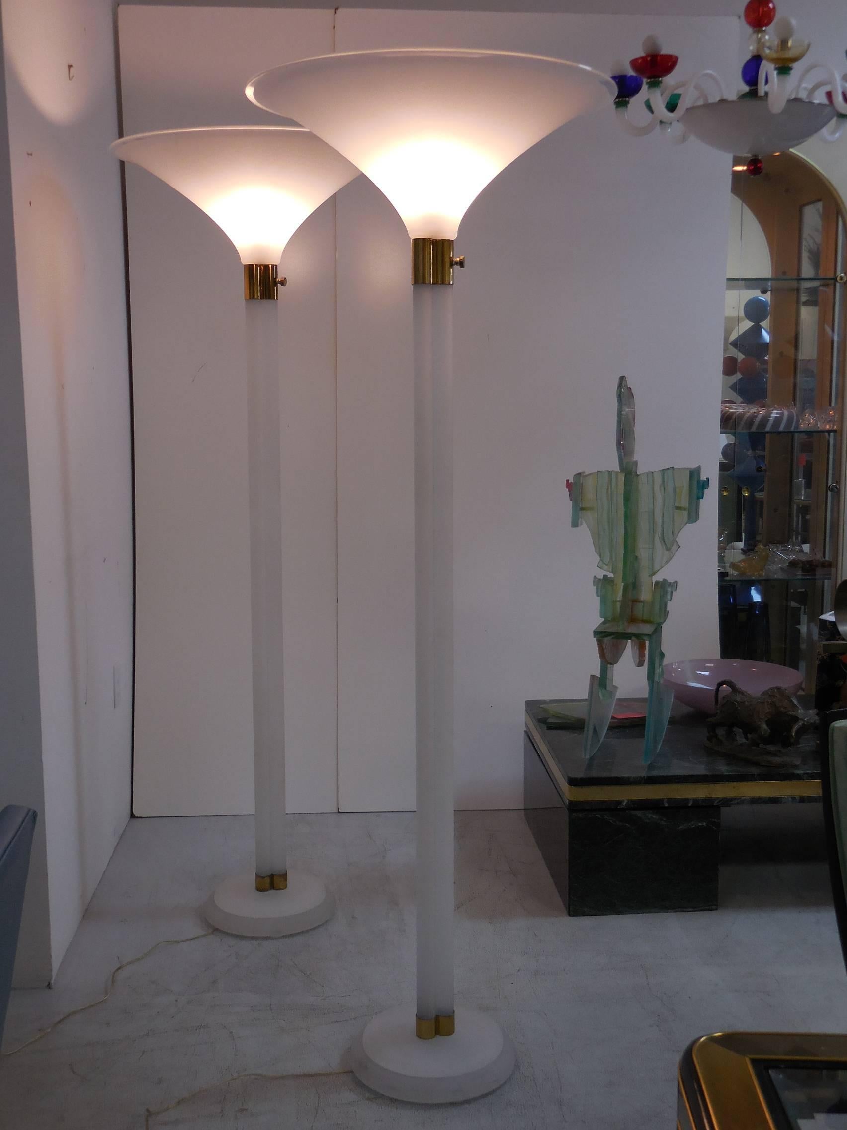 A pair of large sand blasted Lucite torchieres by Karl Springer. Three rod shafts with brass collars. Dimmer switch.