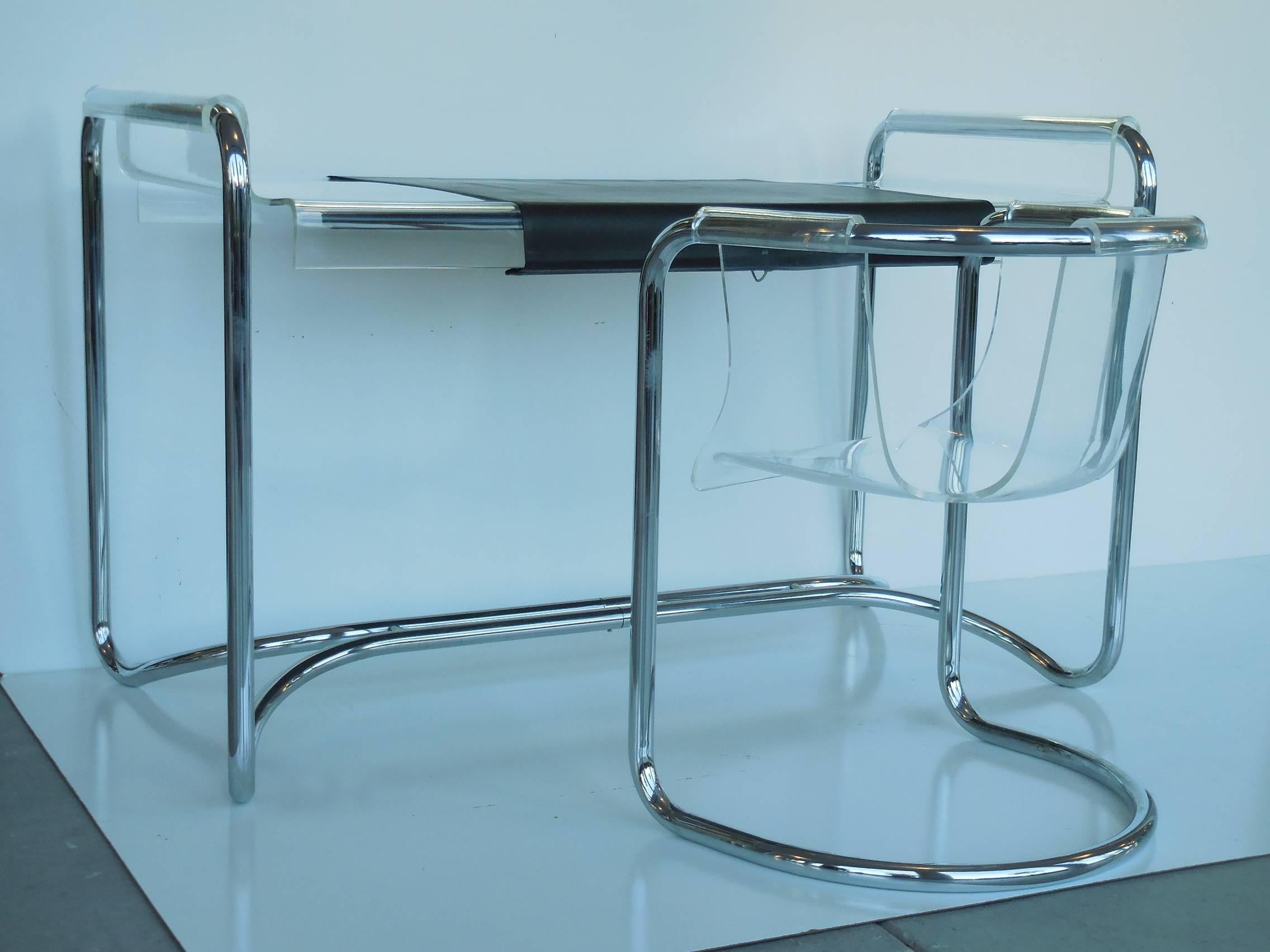 A super stylish desk. Chrome frame with a floating Lucite top. The top retains the original removable leather surface and pencil holders. Two chairs are included.