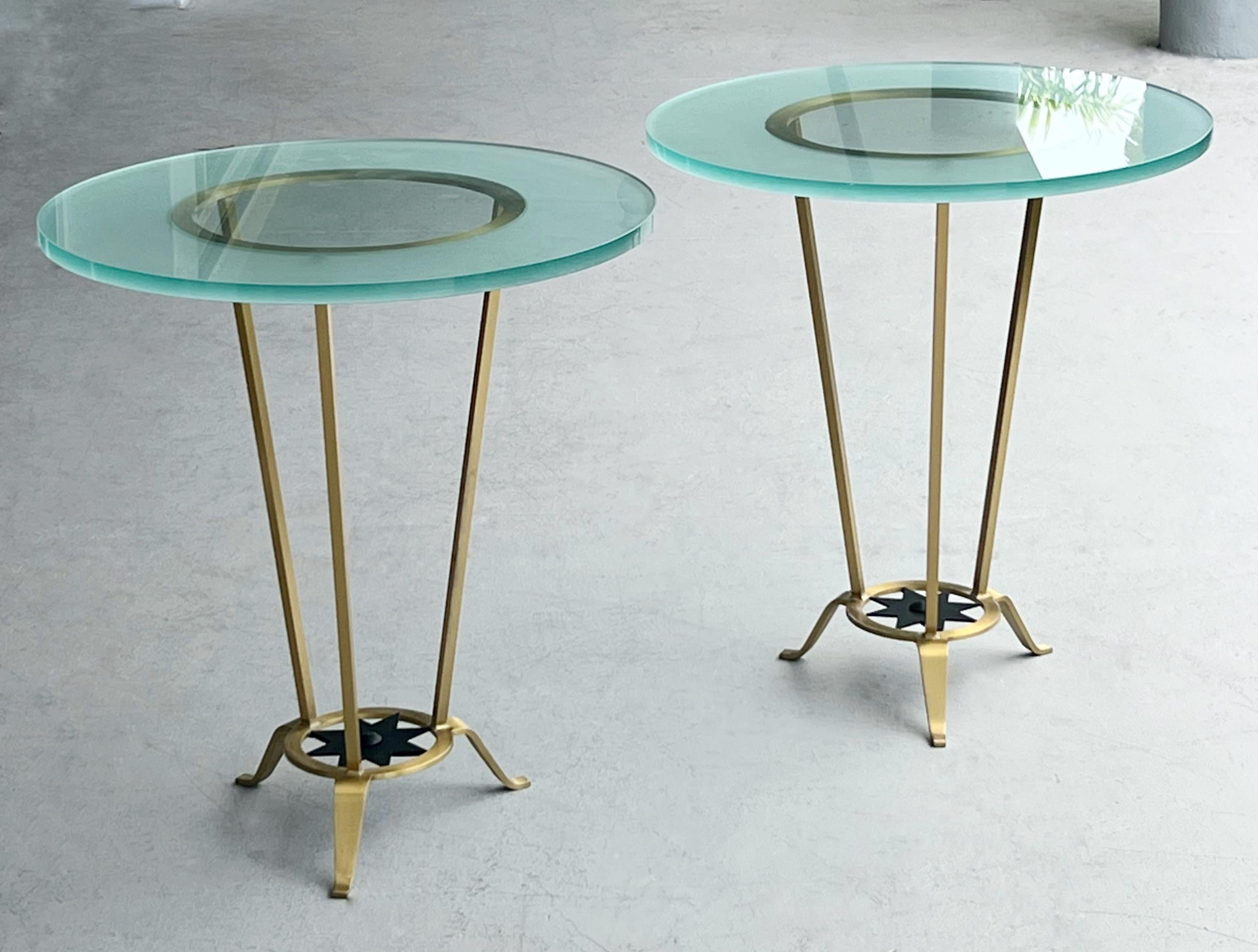 Un gueridon in ottone e vetro. Molto elegante con 3 graziose gambe e un piano in vetro rotondo da 3/4 di pollice. Nota il dettaglio della stella sulla base. 2 tavoli disponibili.