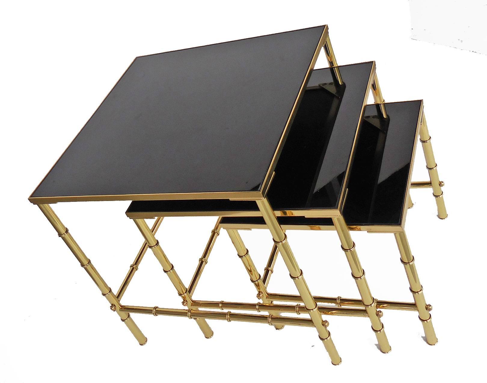 A beautiful set of solid brass nesting tables with black glass tops. Exquisite design and masterfully executed.