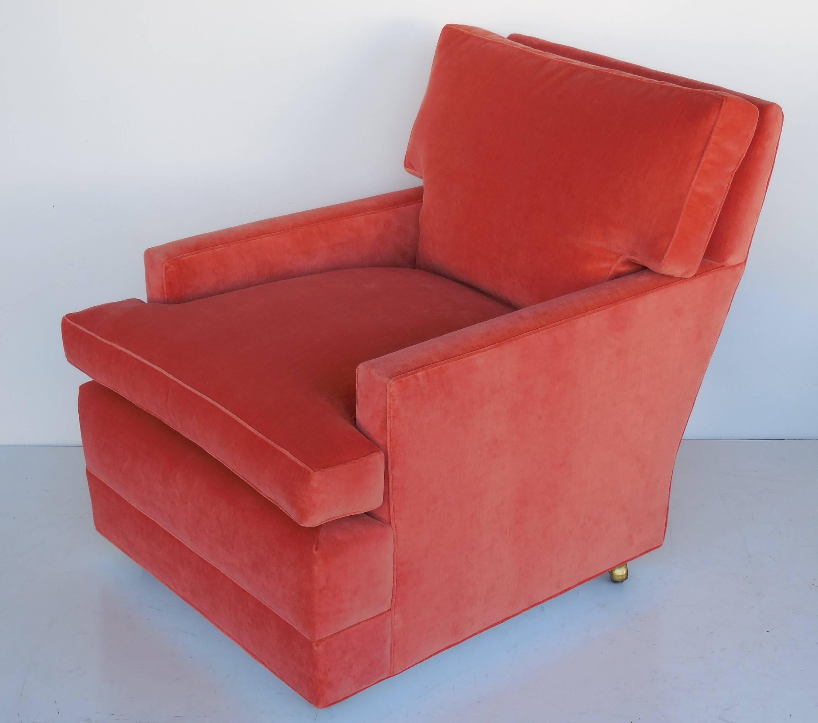 A pair of lounge chairs on casters, in the style of designs by Paul Frankl. Redone in tangerine velvet.