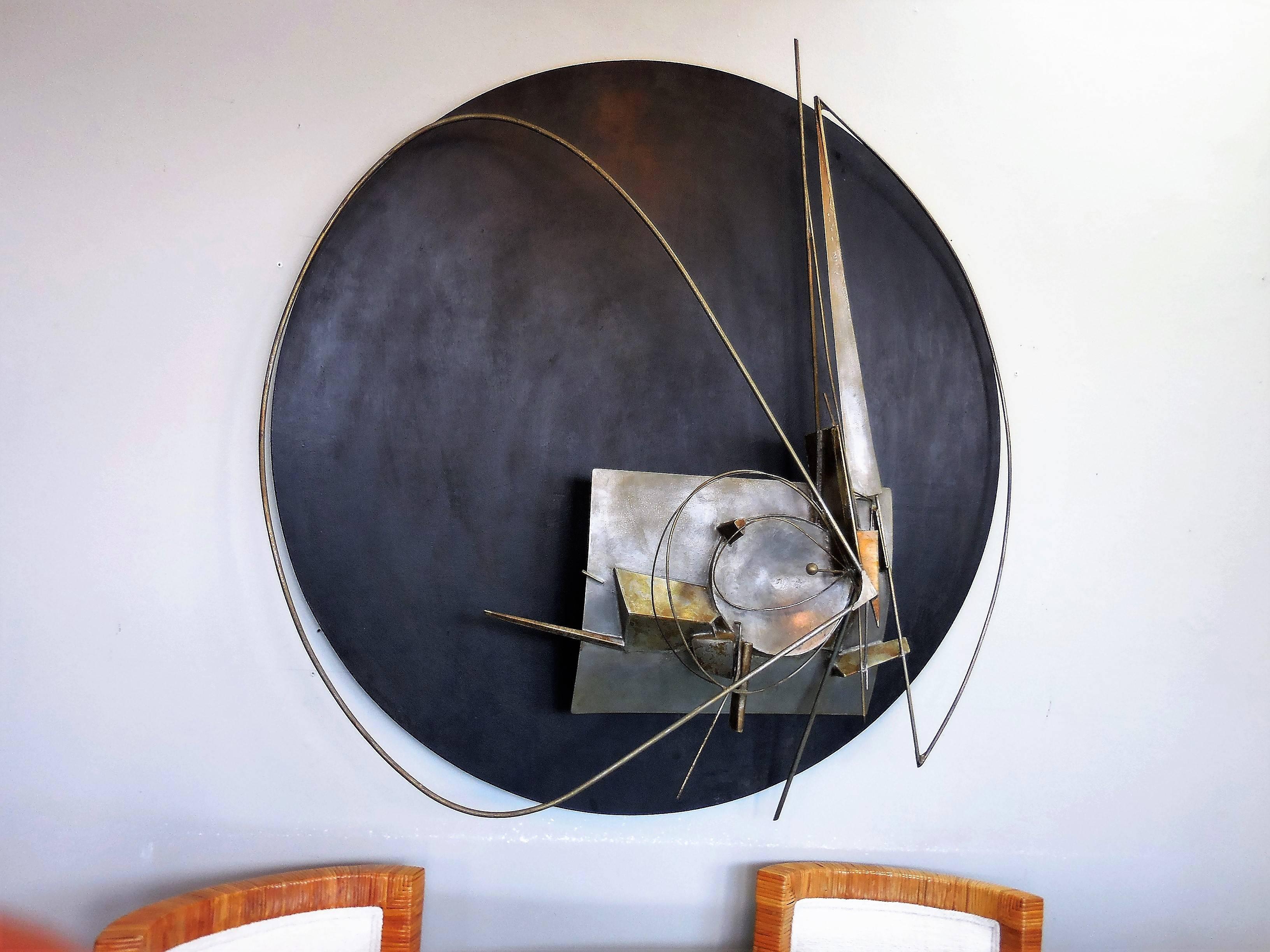 A large wall sculpture by Jean Gubellini. Metal construction with a black wood background. Signed, and retains gallery label on verso.  

  
