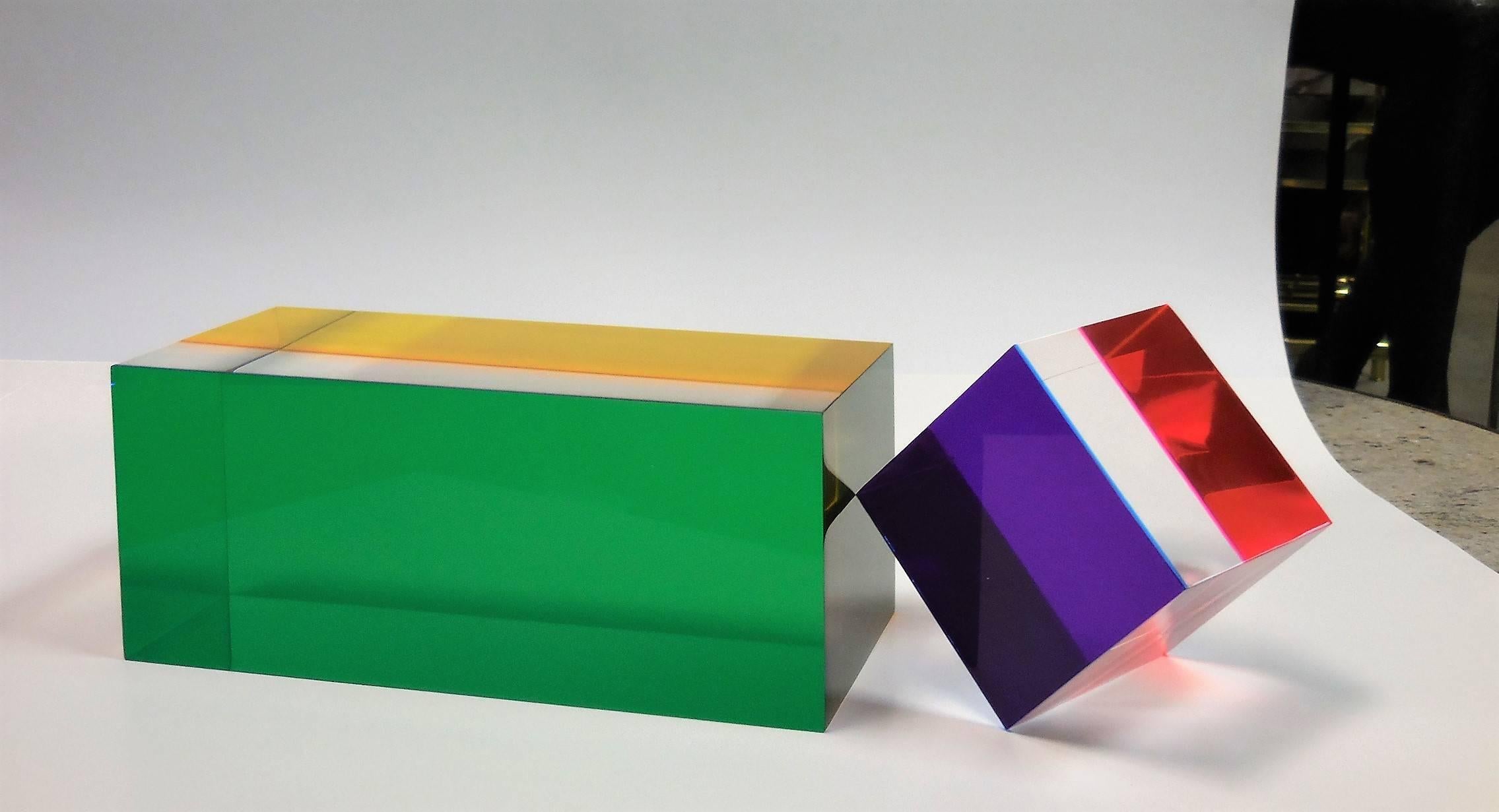 A colorful Lucite sculpture, 2 solid acrylic blocks. It can be arranged in multiples configurations. Color perception varies depending on point of view, lighting condition and surrounding. Large block is 5 in by 5 in by 11 in, cube is in by 4 in by