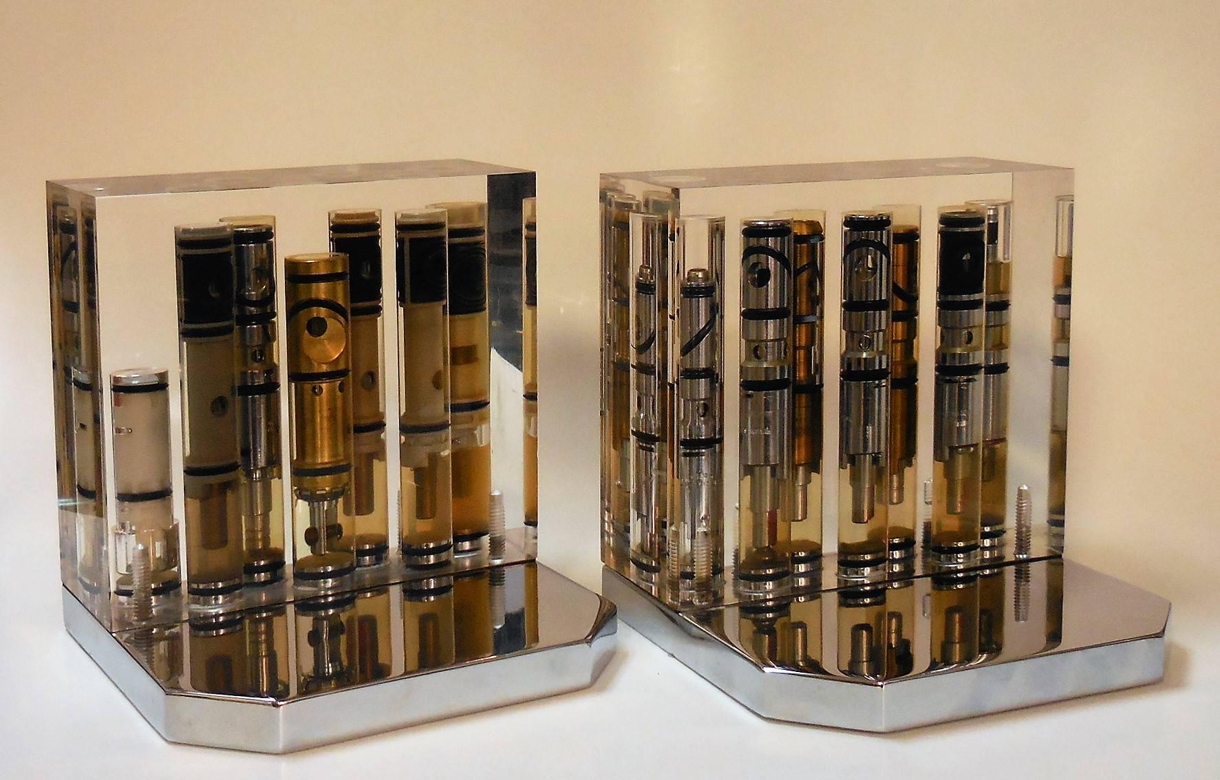 A pair of unique bookends, valves suspended in acrylic with a thick and solid stainless steel base.