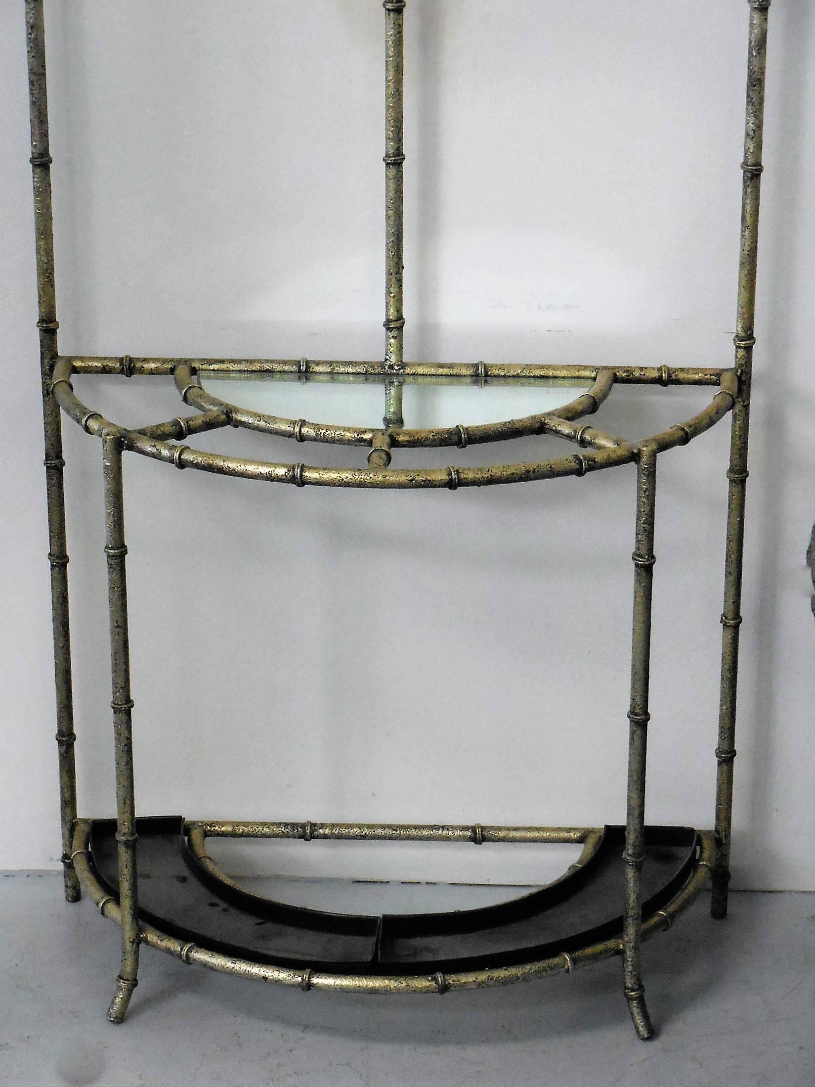 Rare and beautiful hall tree. It is metal with a thick silver enamel finish. There are three stylized hooks around the round looking glass. The console top is mirror as well.