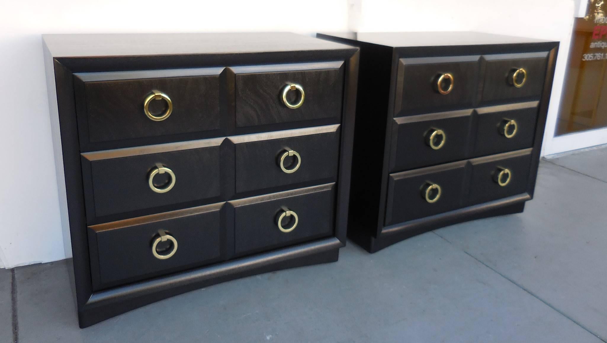 Classic and modern pair of cabinets. Three deep drawers for lots of storage. Original brass pulls. Newly re-finished in ebony stain retaining the wood undertones. Ideal for bed side tables. Finished backs as well.